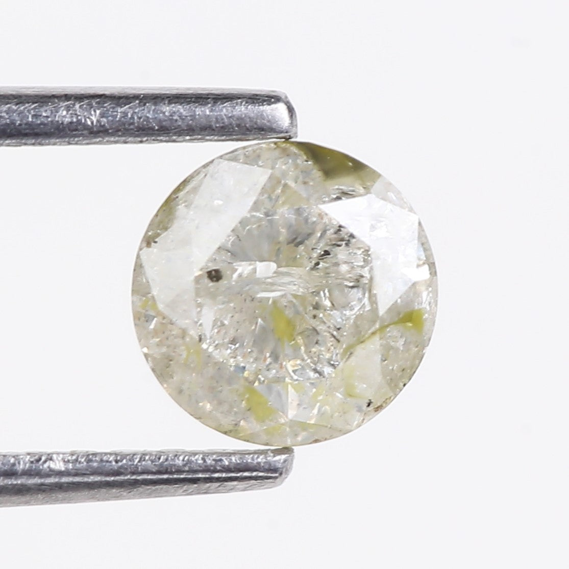 Round diamond held between two silver prongs on a white background
