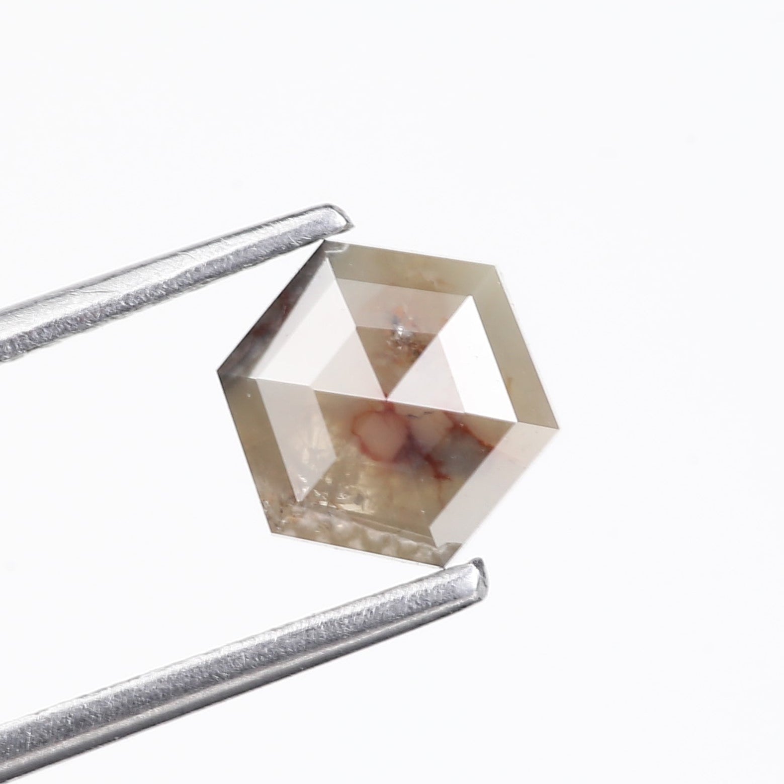 Diamond held by tweezers on a white background