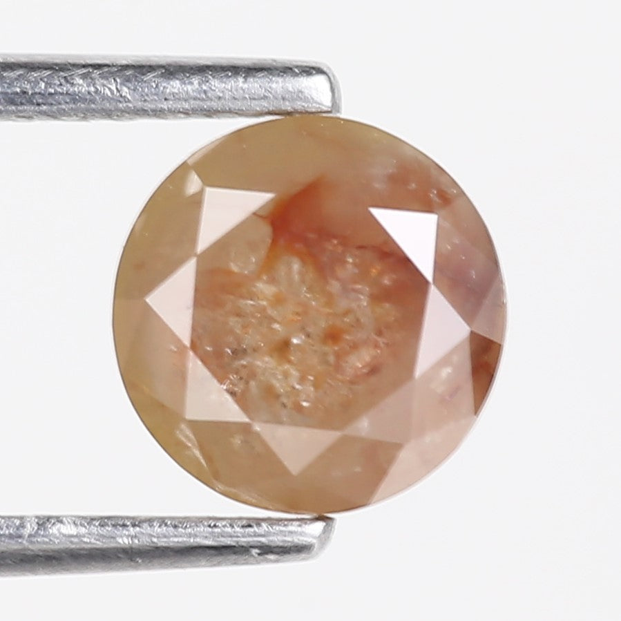 Faceted gemstone held between two metal prongs on a white background