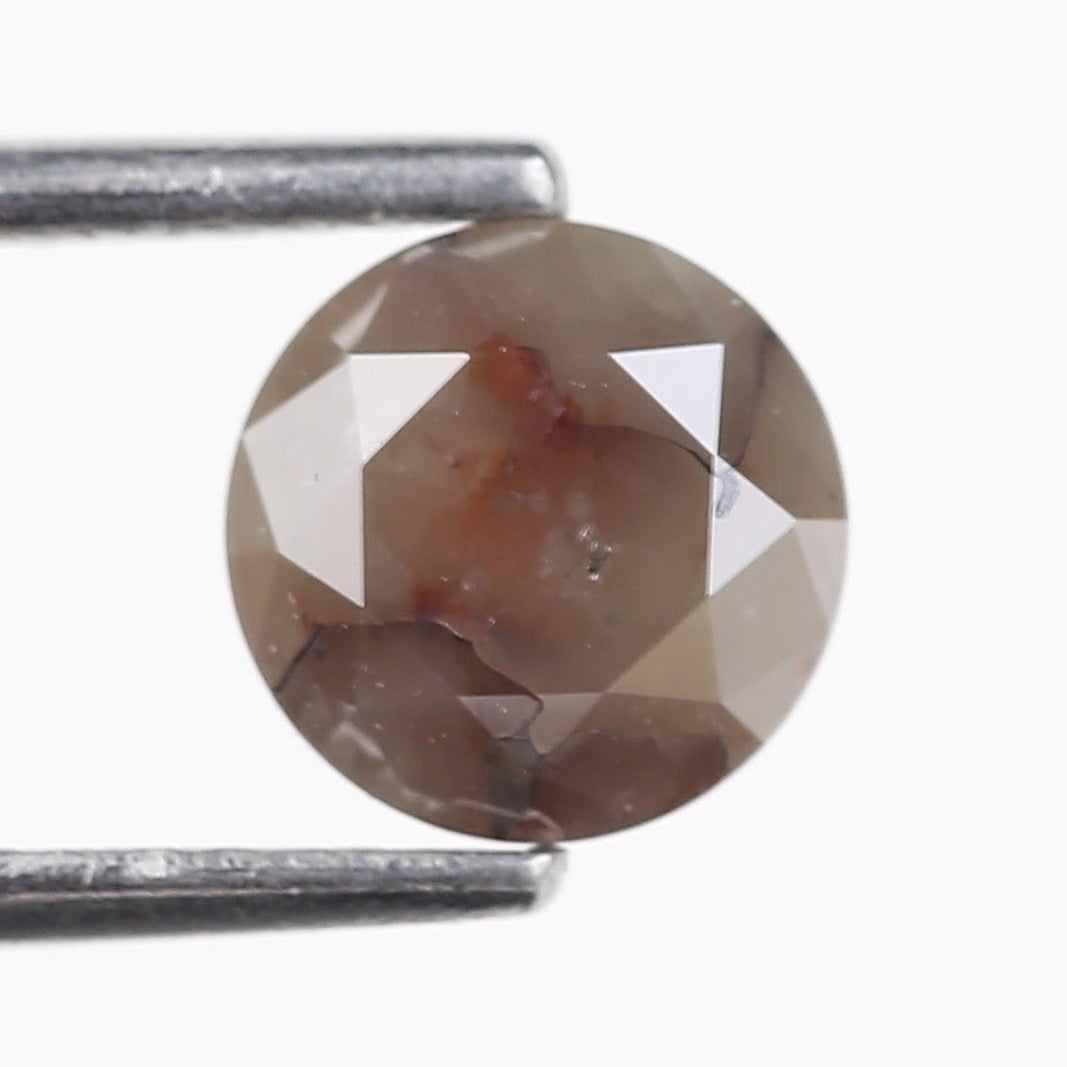 Faceted diamond held between tweezers on a white background
