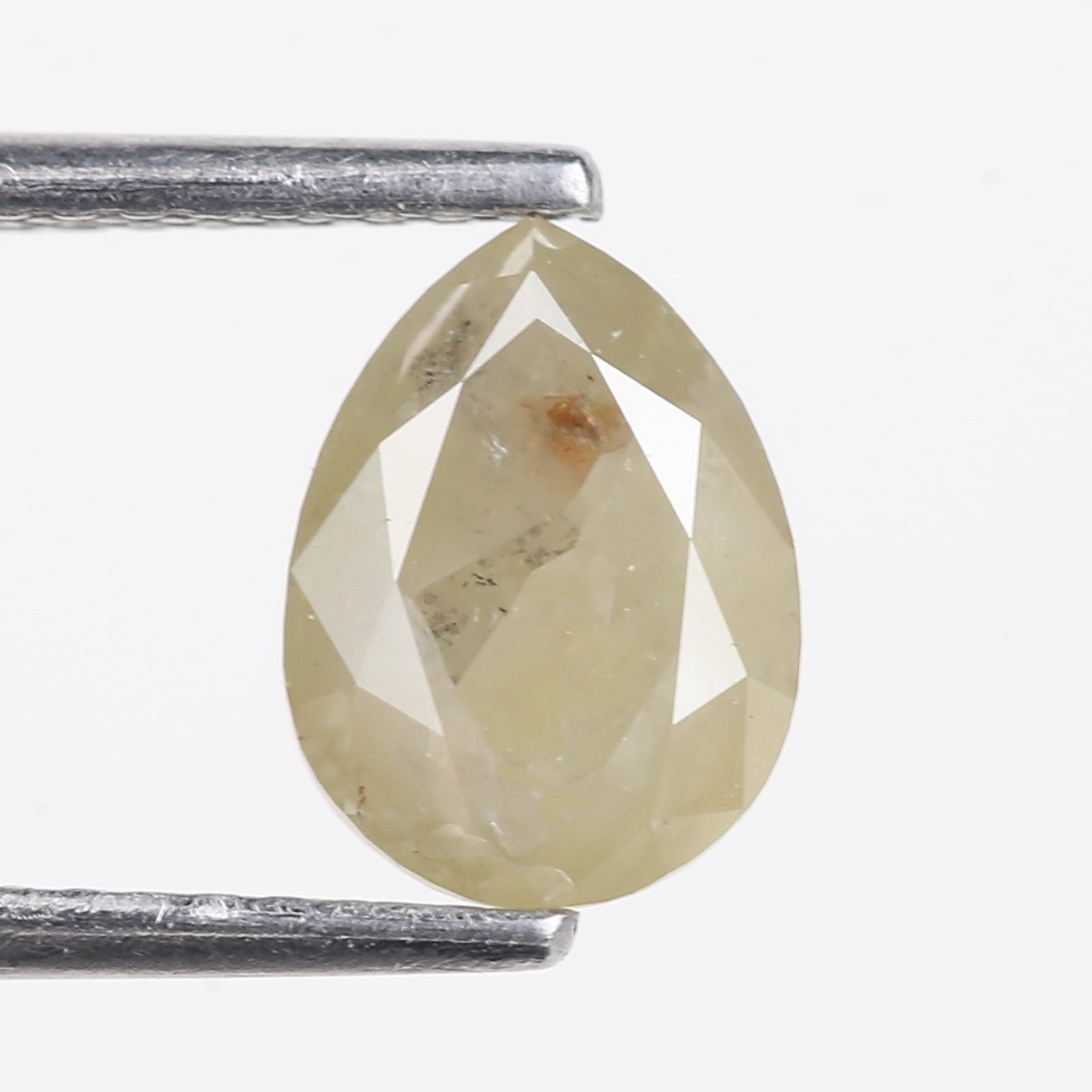 Teardrop-shaped diamond held between two metal prongs on a white background