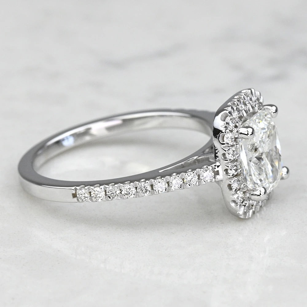 Diamond ring with a white gemstone on a light gray background