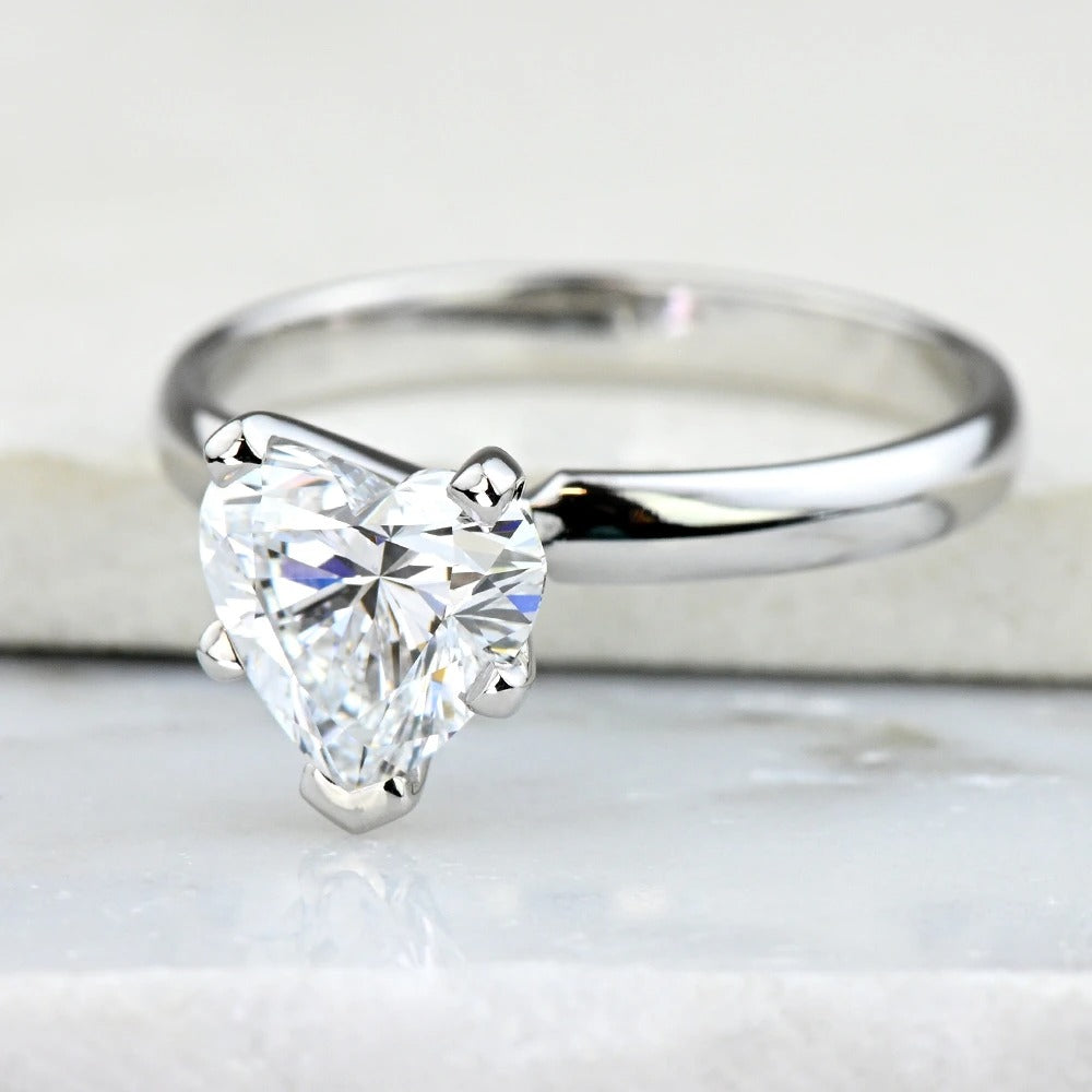 white gold ring with a heart-shaped diamond on a white background