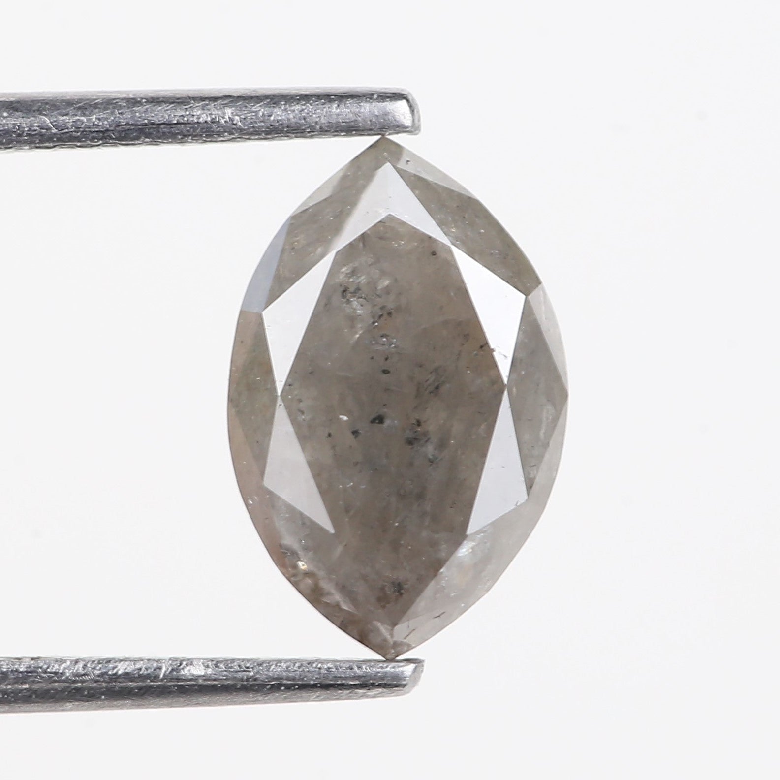 Salt and Pepper Diamond Marquise 9.79 MM held between two metal prongs on a white background