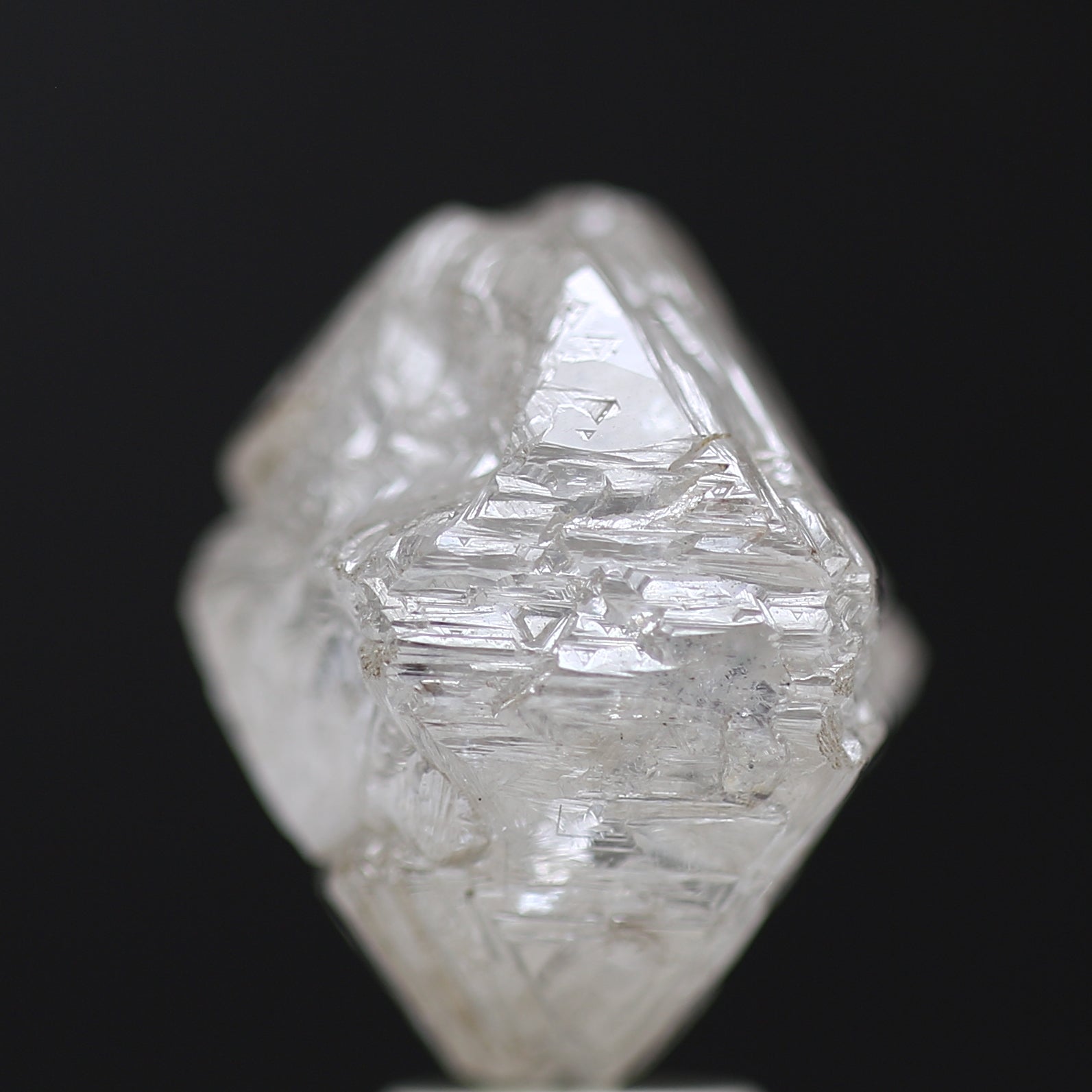 Crystal rough diamond white octahedron on a black background