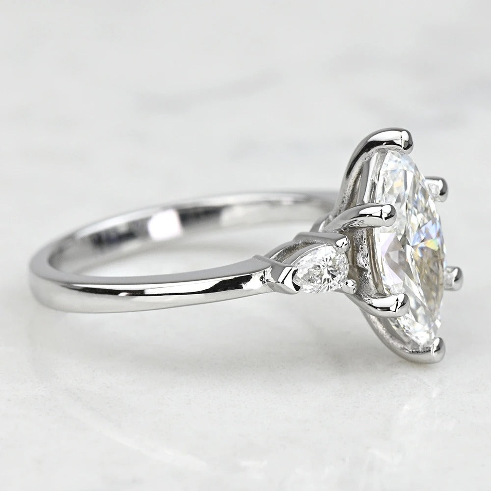white gold ring with a large diamond and smaller diamonds on a light gray background