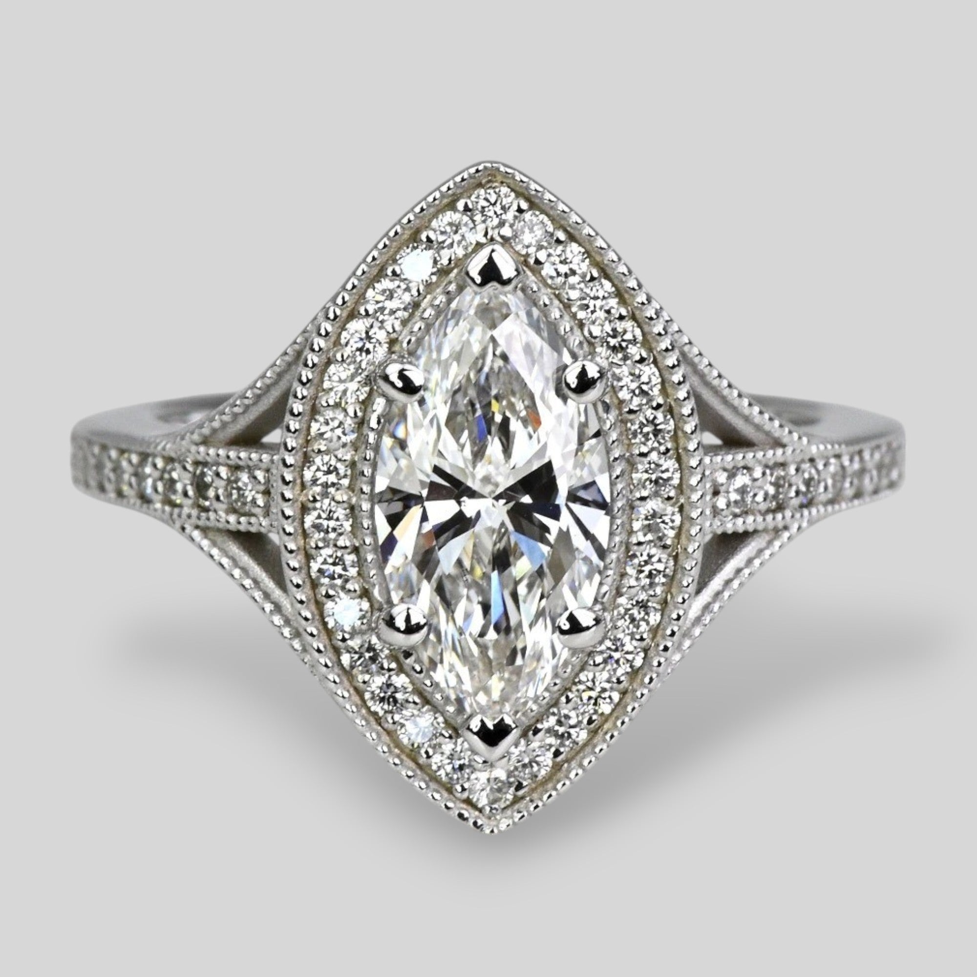 Diamond ring with marquise shaped center stone on a light gray background