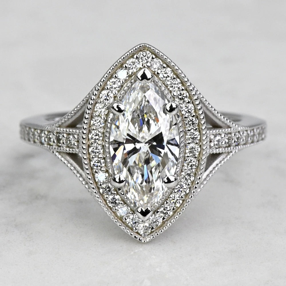 Diamond ring with marquise-shaped center stone on a light gray background
