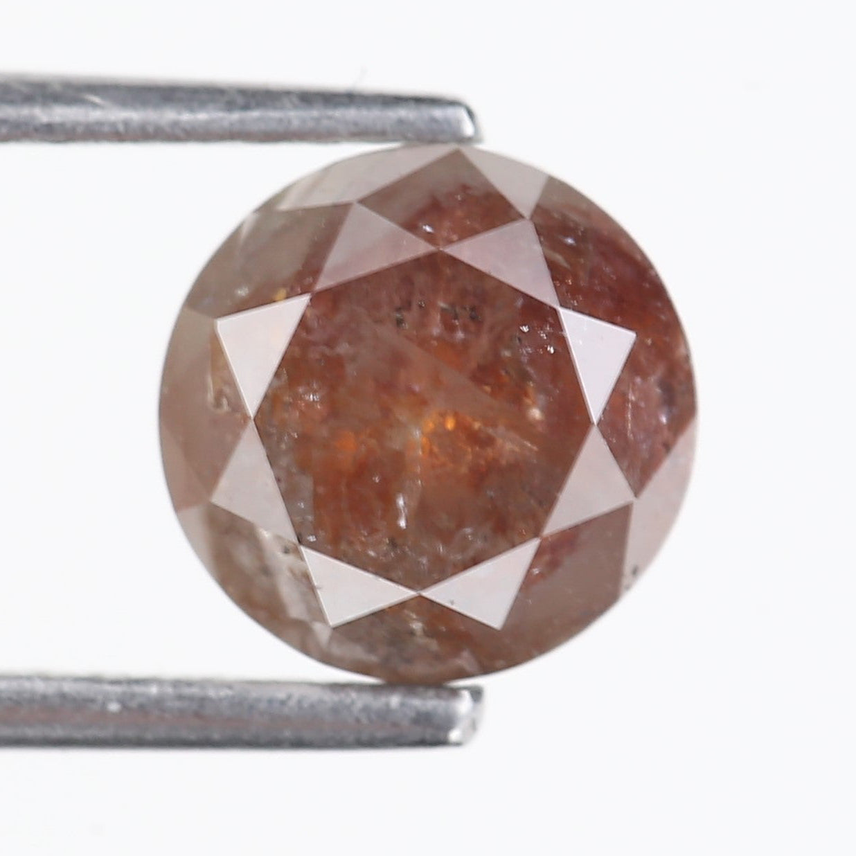 orange diamond held between two metal prongs on a white background