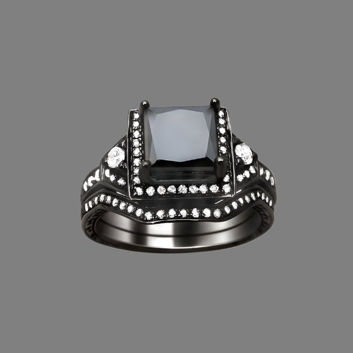 A black gold engagement ring with a princess cut black diamond surrounded by smaller white diamonds, accompanied by a matching band.