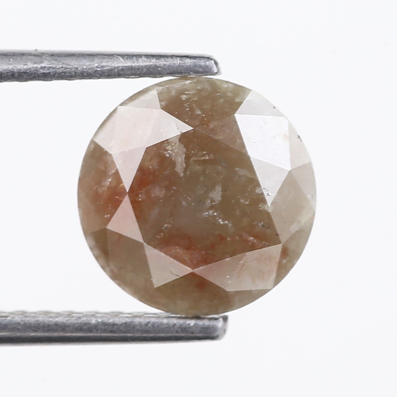 Round cut gemstone held between two metal prongs on a white background