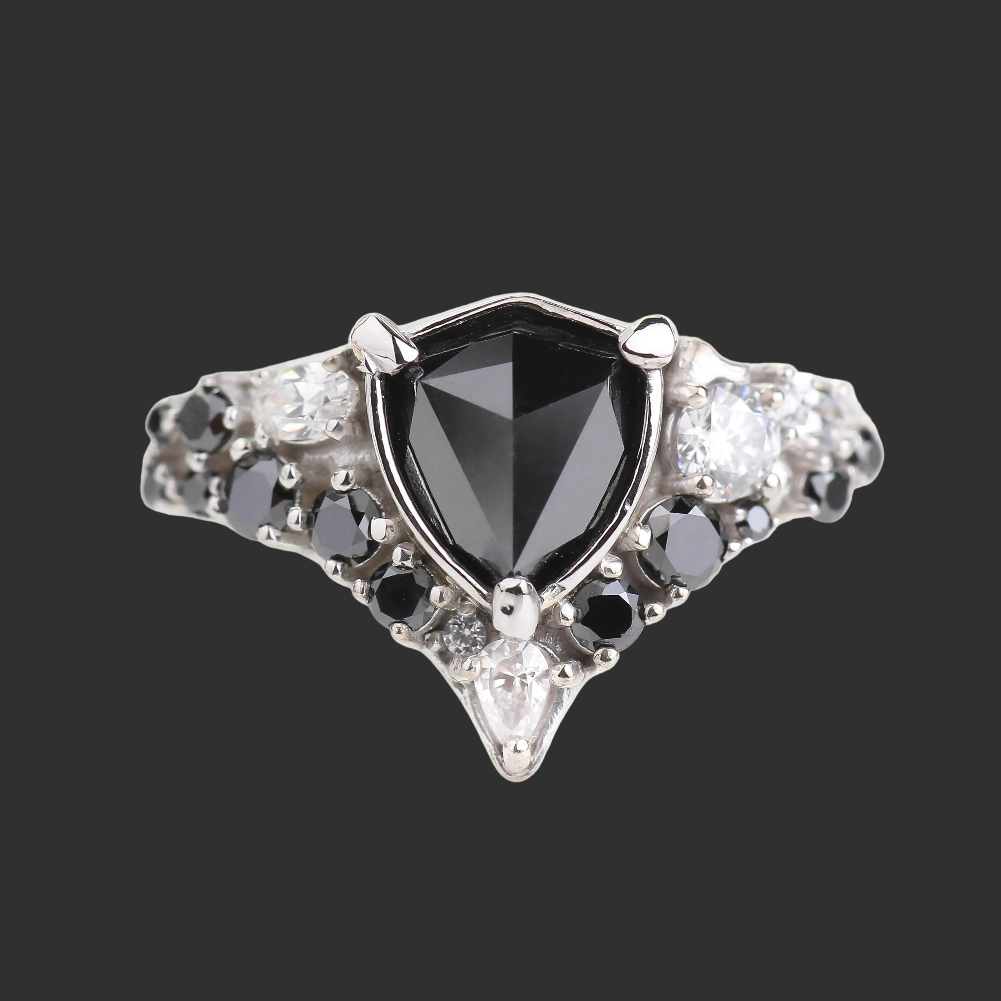 Elegant ring with a black gemstone and diamond accents on a white background