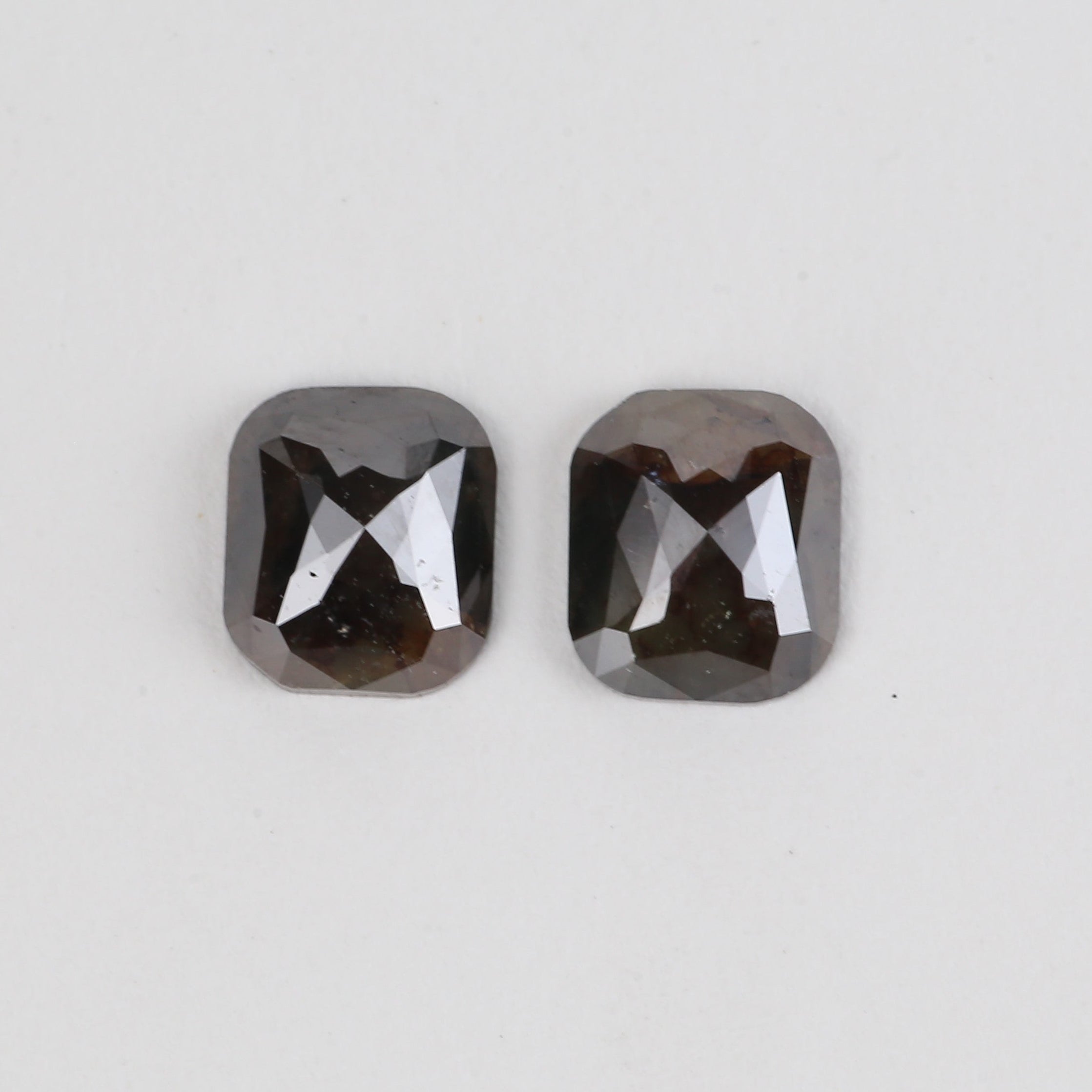 Two faceted diamond on a light gray background