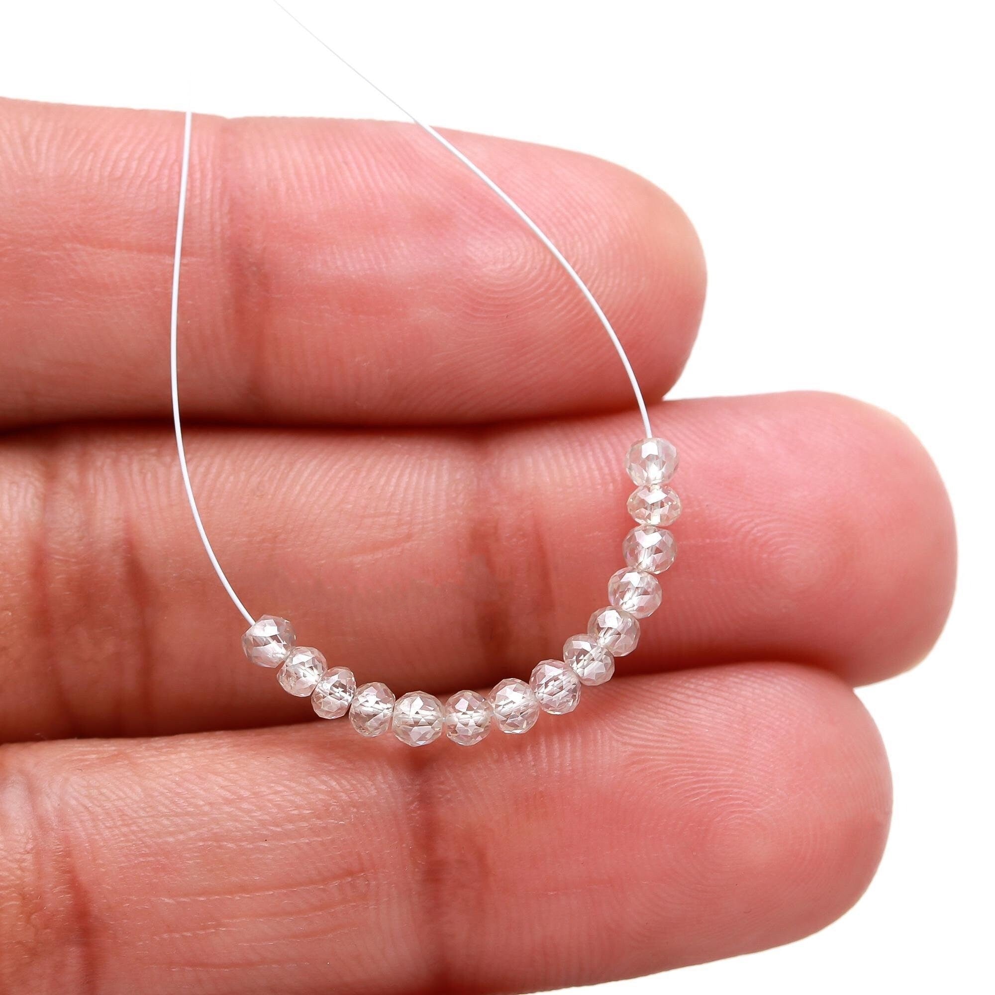 Close-up of a hand holding a small beaded circle with a white background