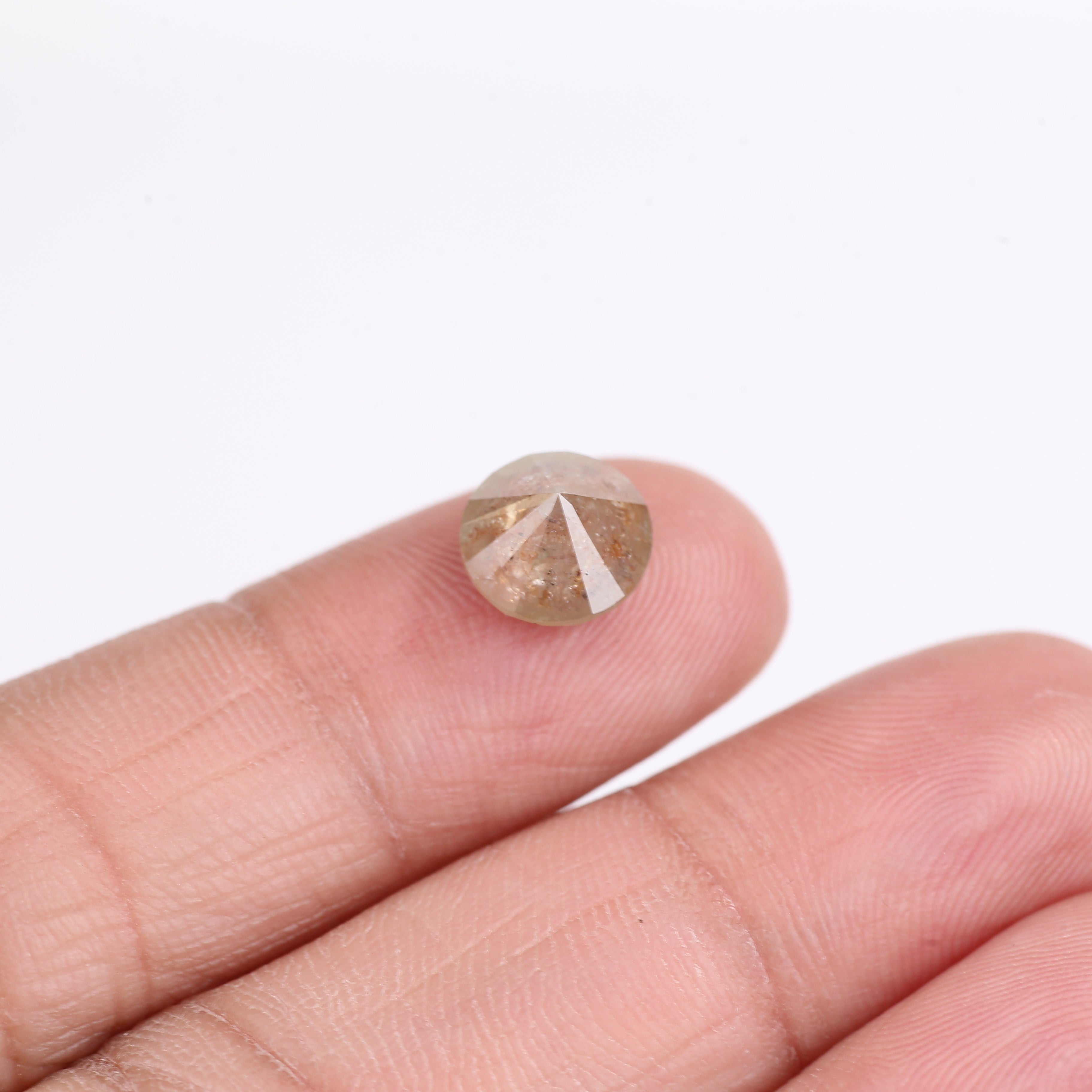 Diamond held between fingers on a white background