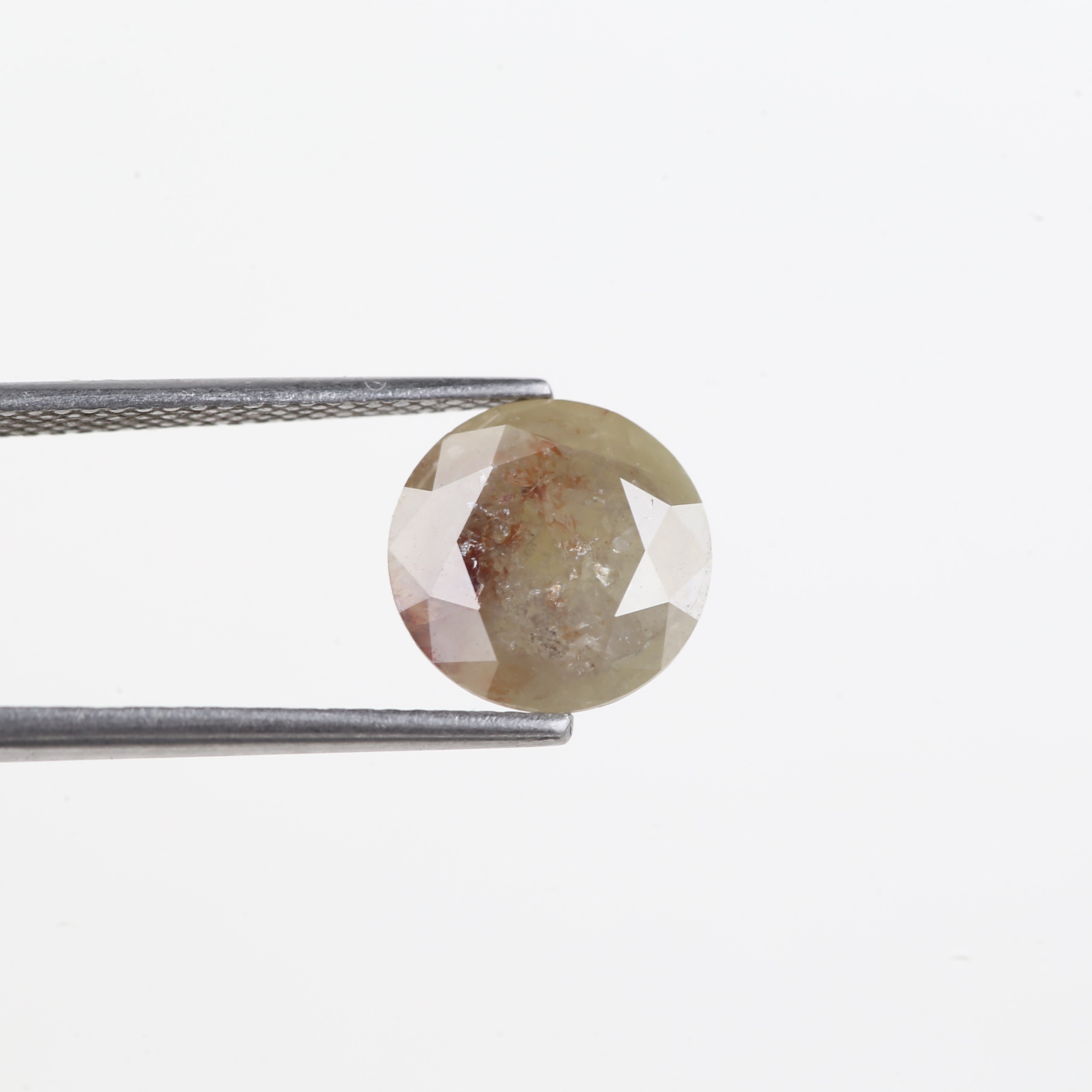 Round cut gemstone held by tweezers on a white background