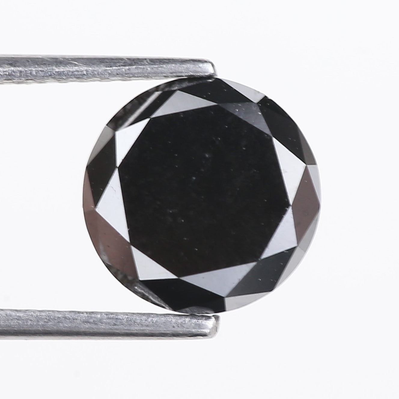 Black diamond held by tweezers on a white background