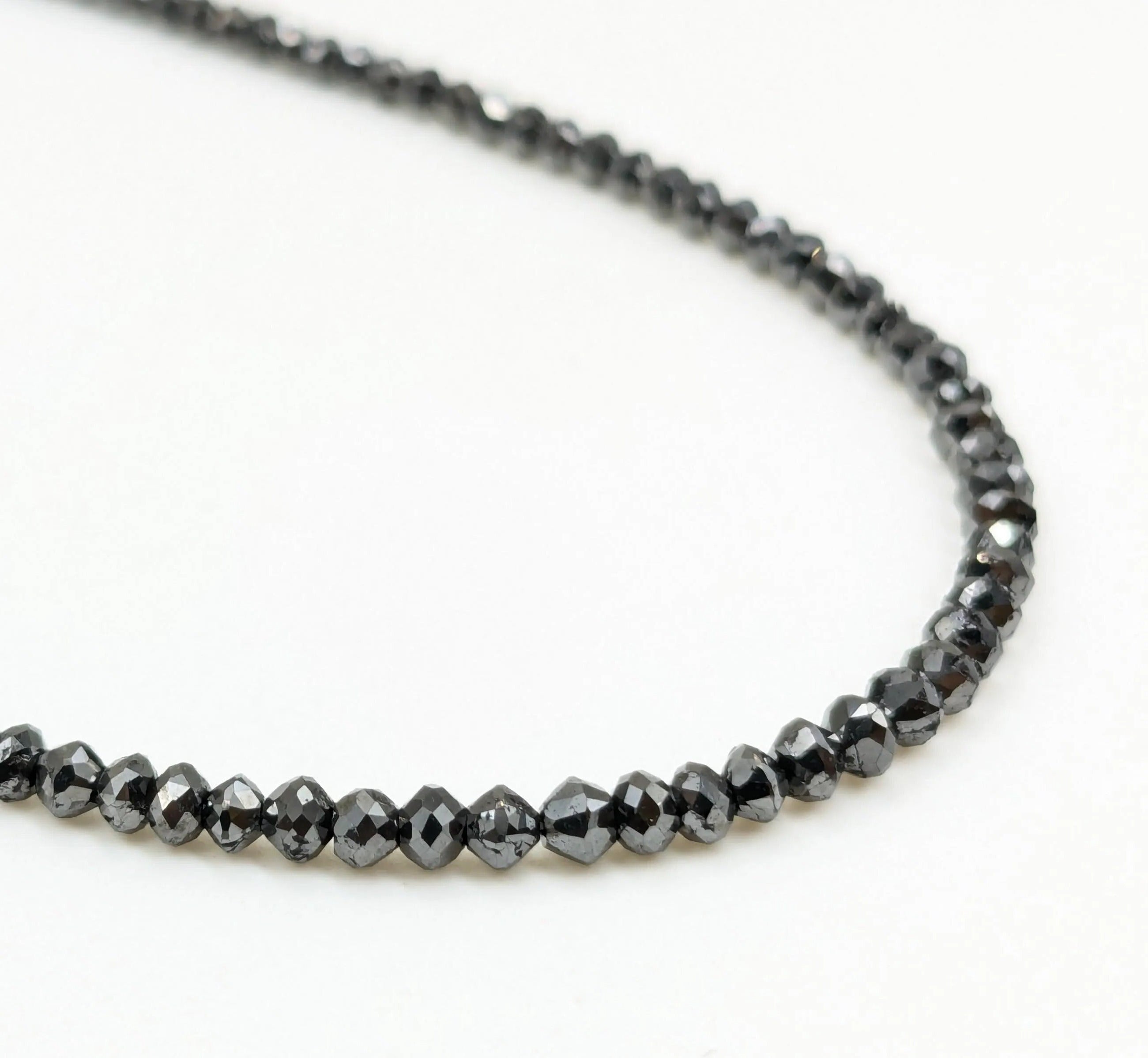 Necklace with black beaded chain on a white background