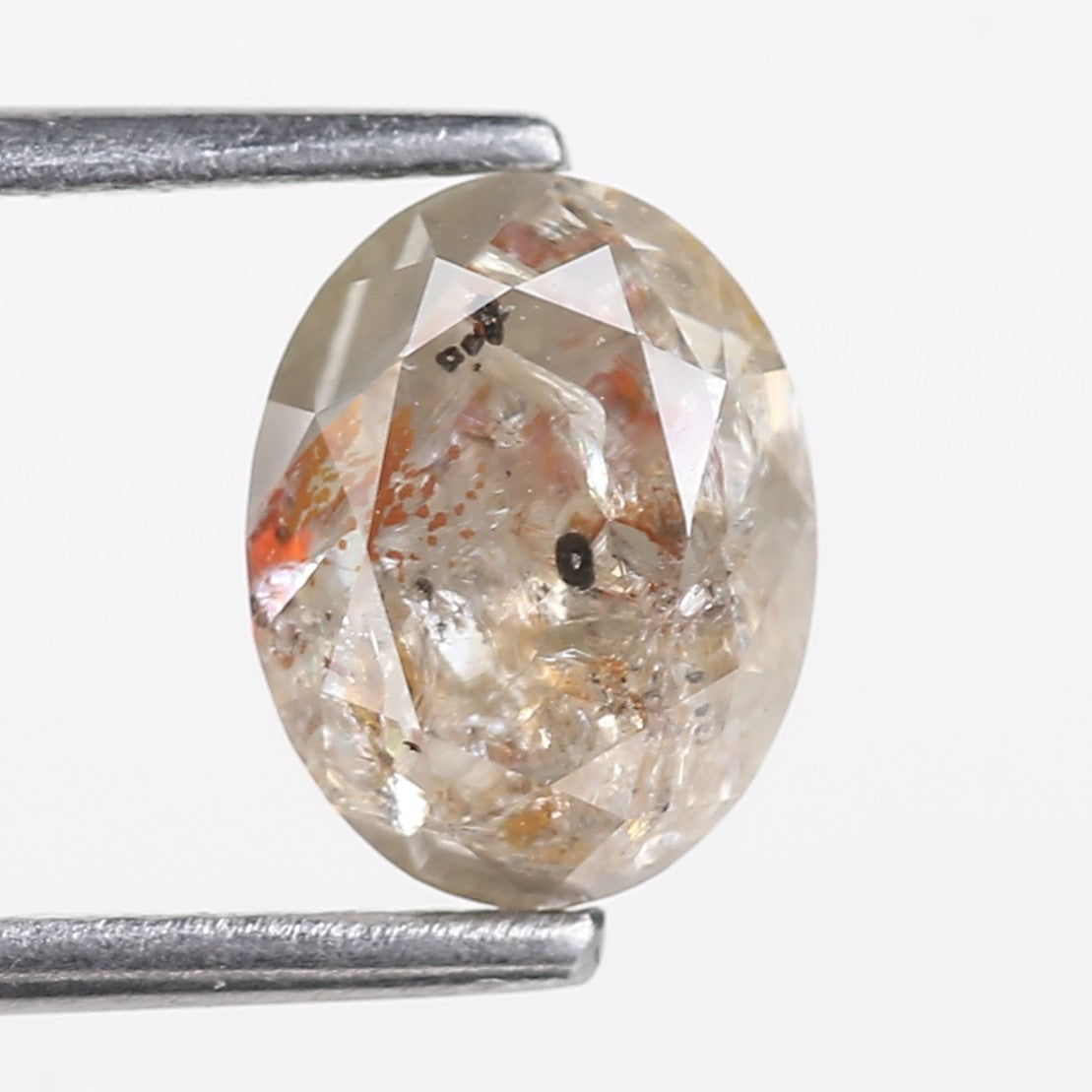 Diamond held between two tweezers on a white background