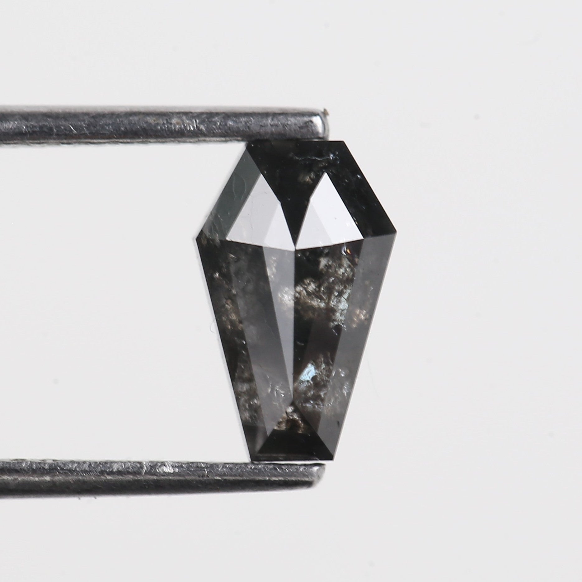 Geometric crystal pendant on a thin rod against a light gray background