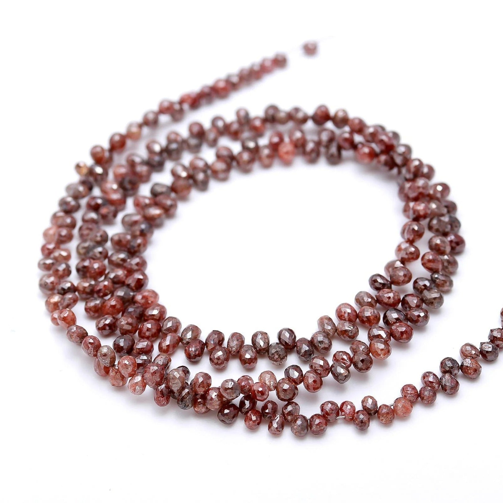 Strand of red gemstone beads on a white background