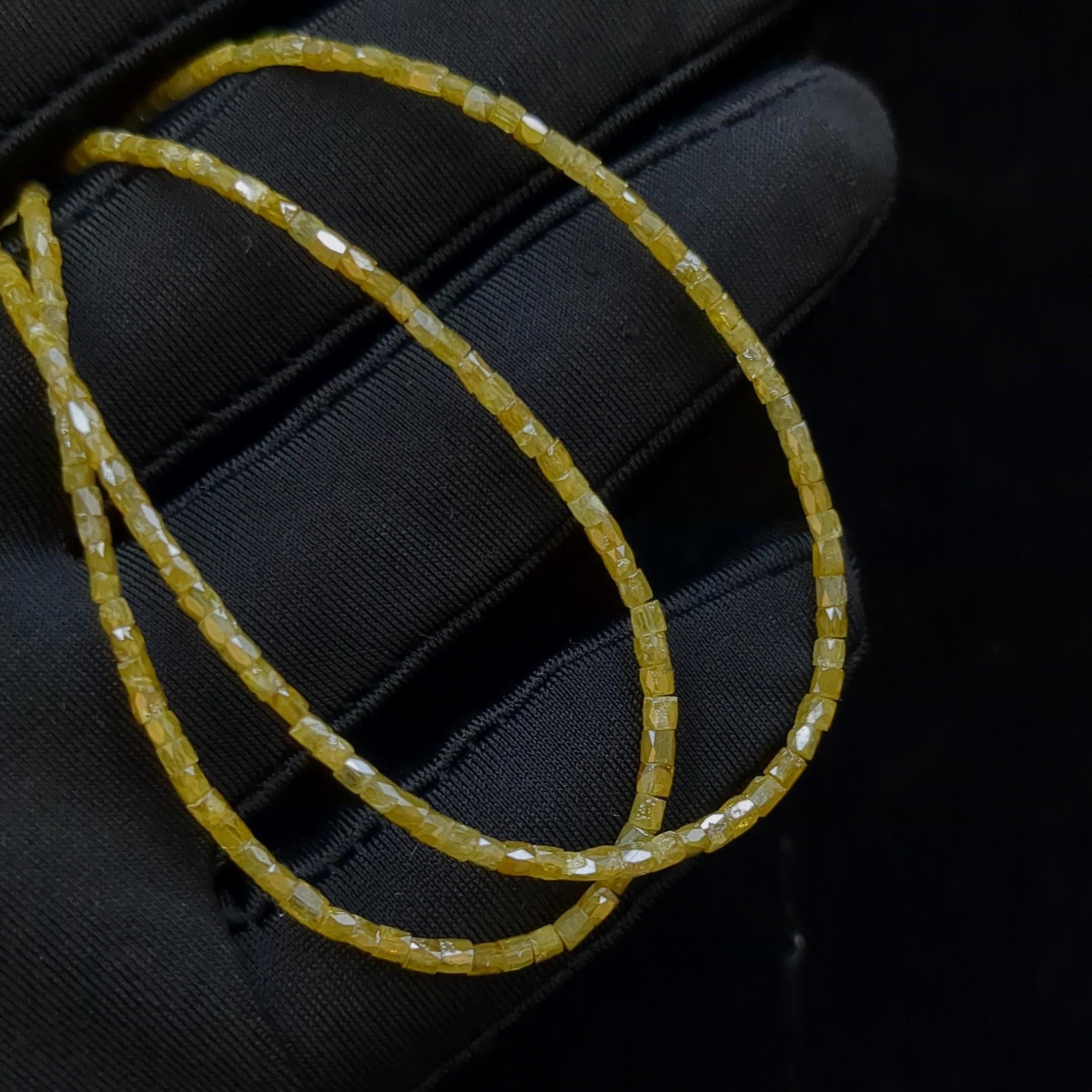 Yellow beaded bracelet on a black textured surface
