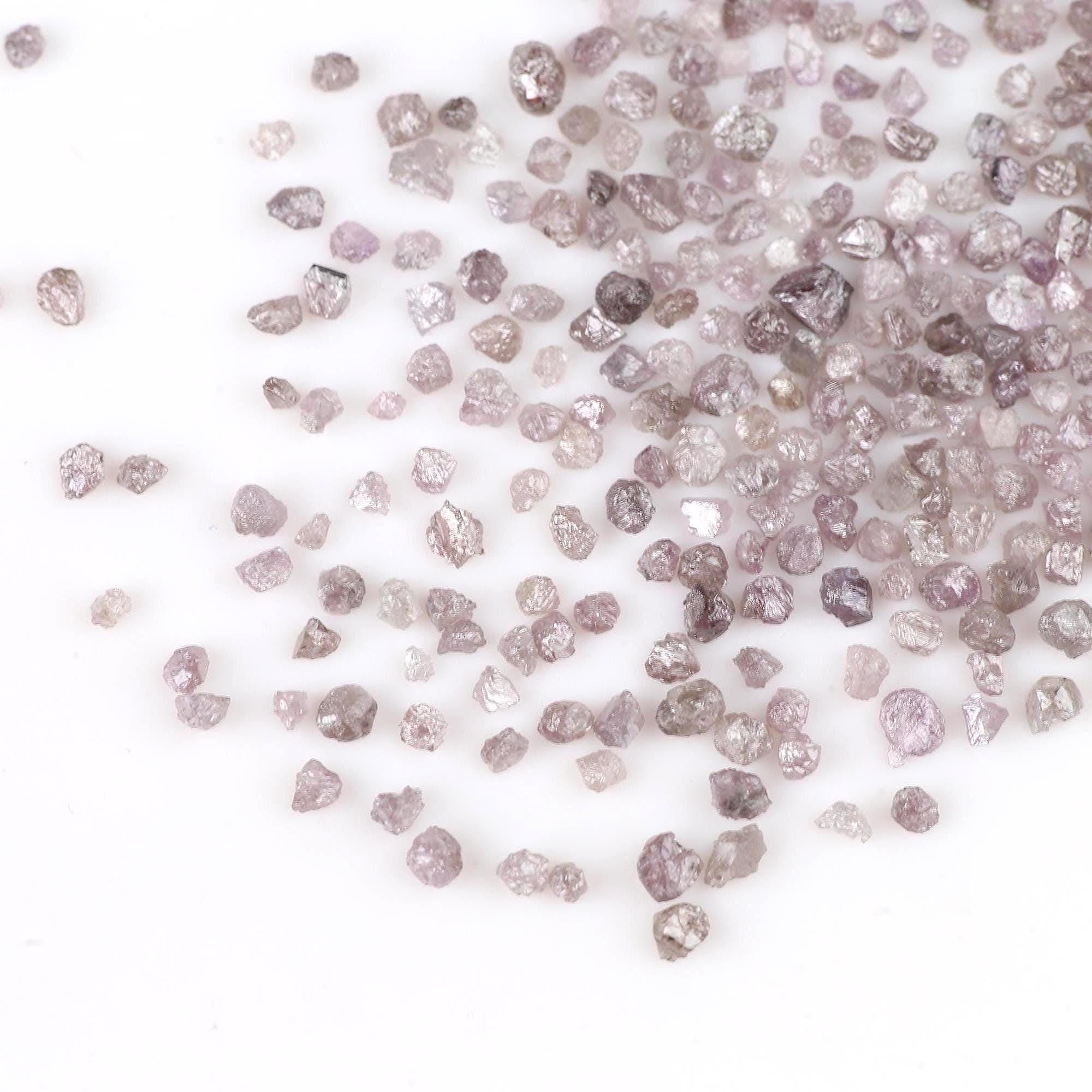 Raw diamonds scattered on a white background