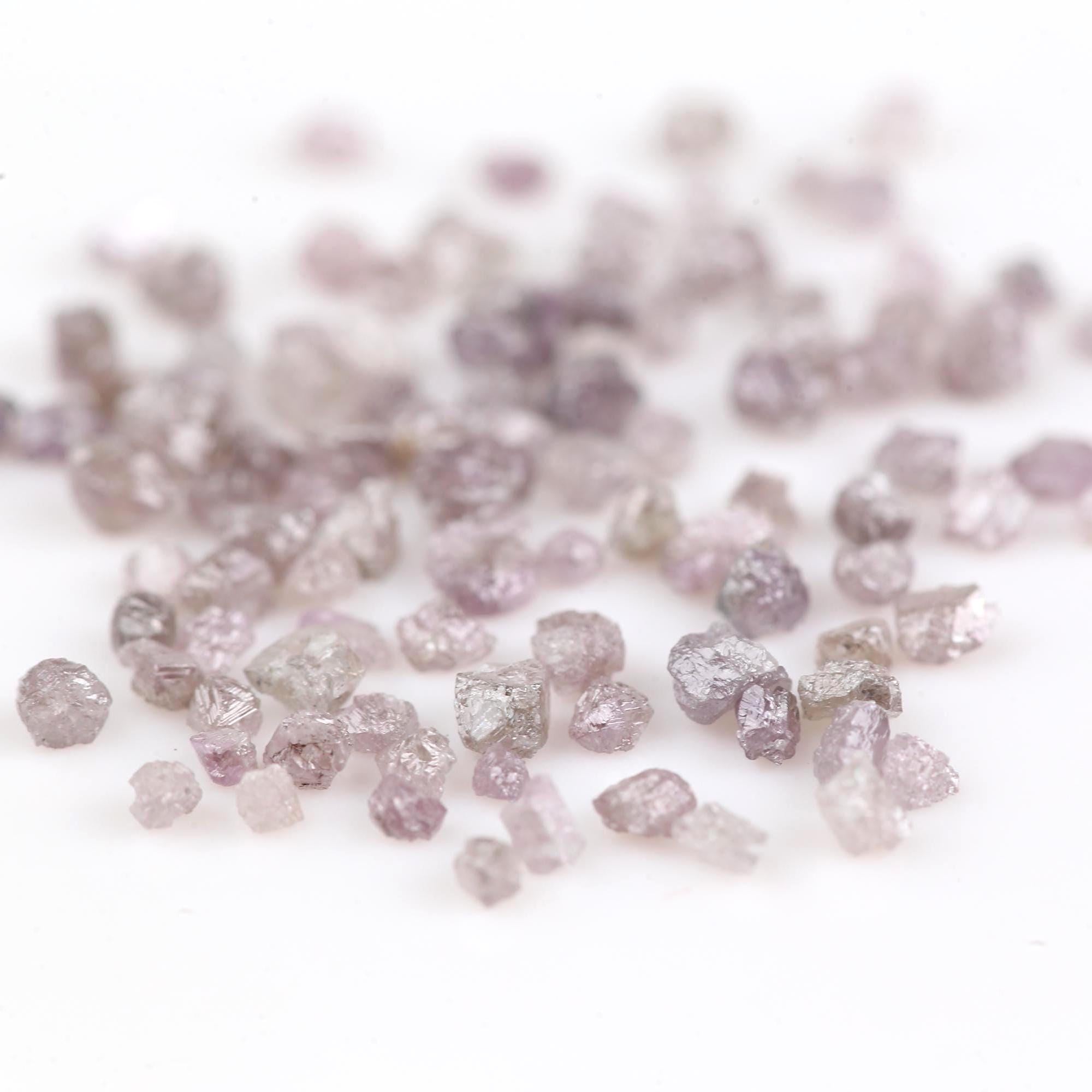 Raw diamonds scattered on a white background