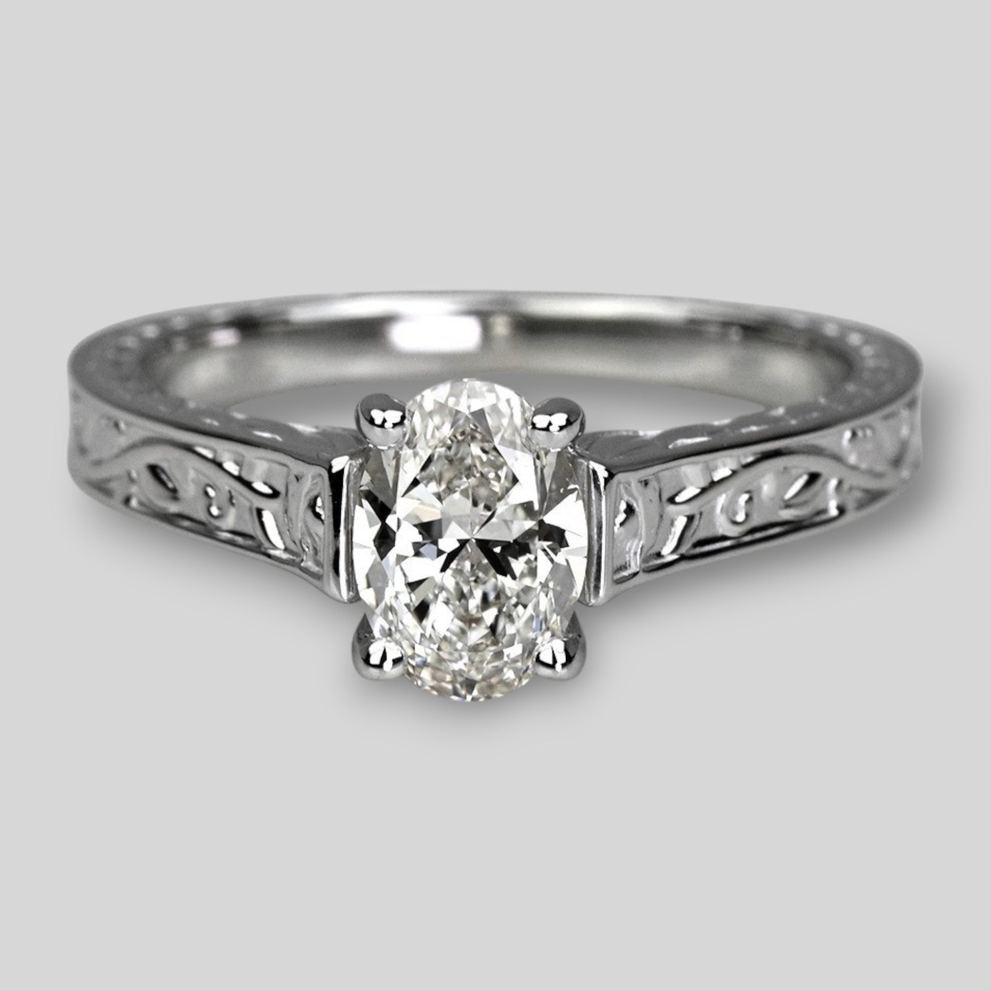 Diamond ring with intricate band on a light gray background