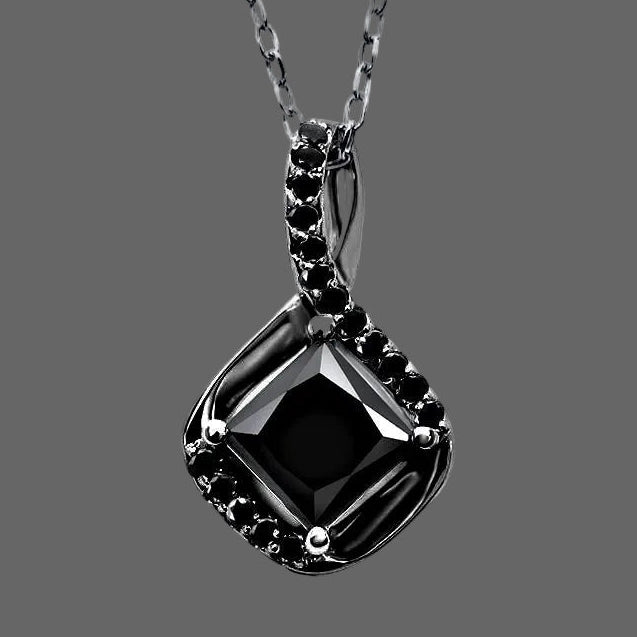 Black diamond pendant on a silver chain against a white background