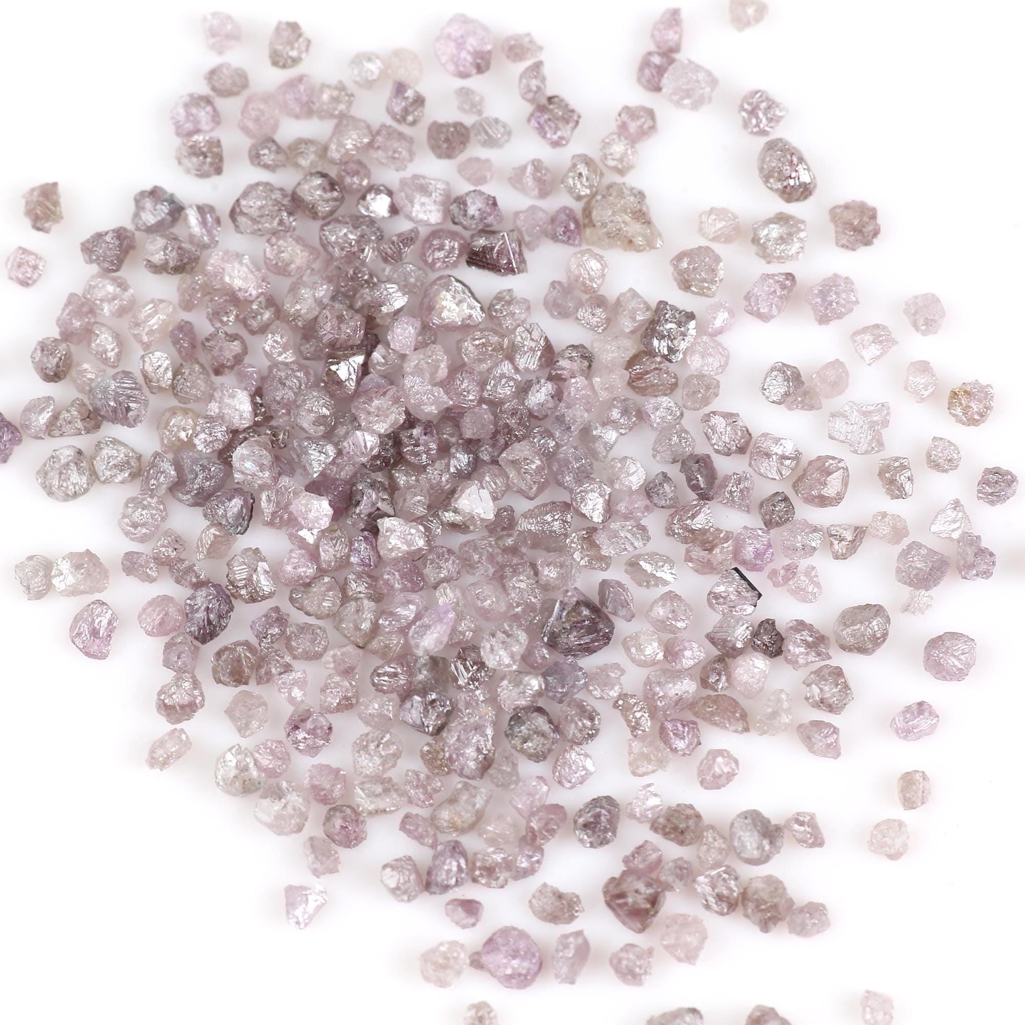 Pink Raw diamonds of various sizes and colors on a white background