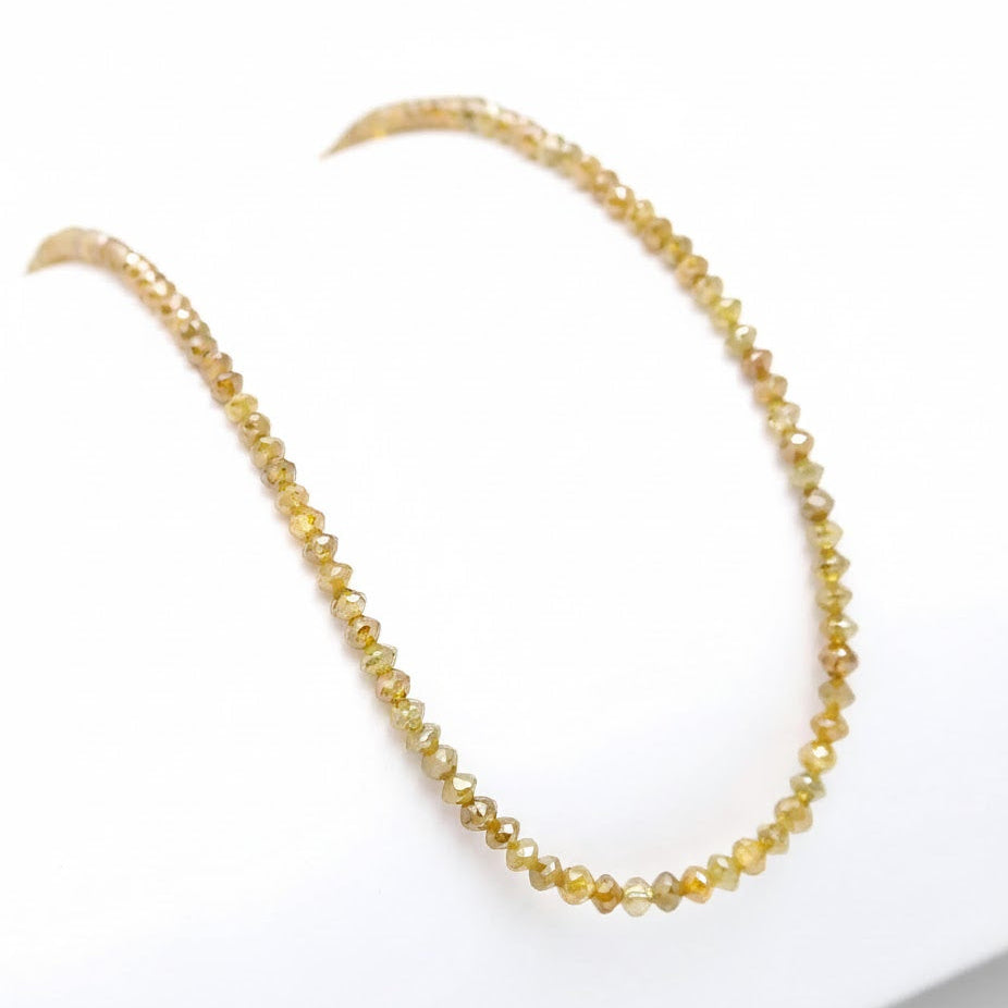 Gold beaded necklace on a white background