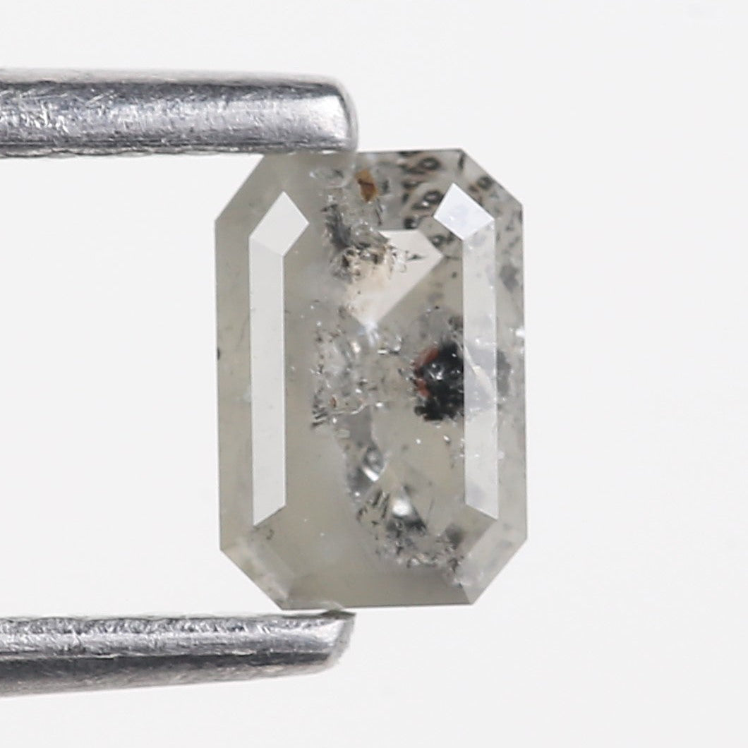 Rectangular diamond held between two metal prongs on a white background