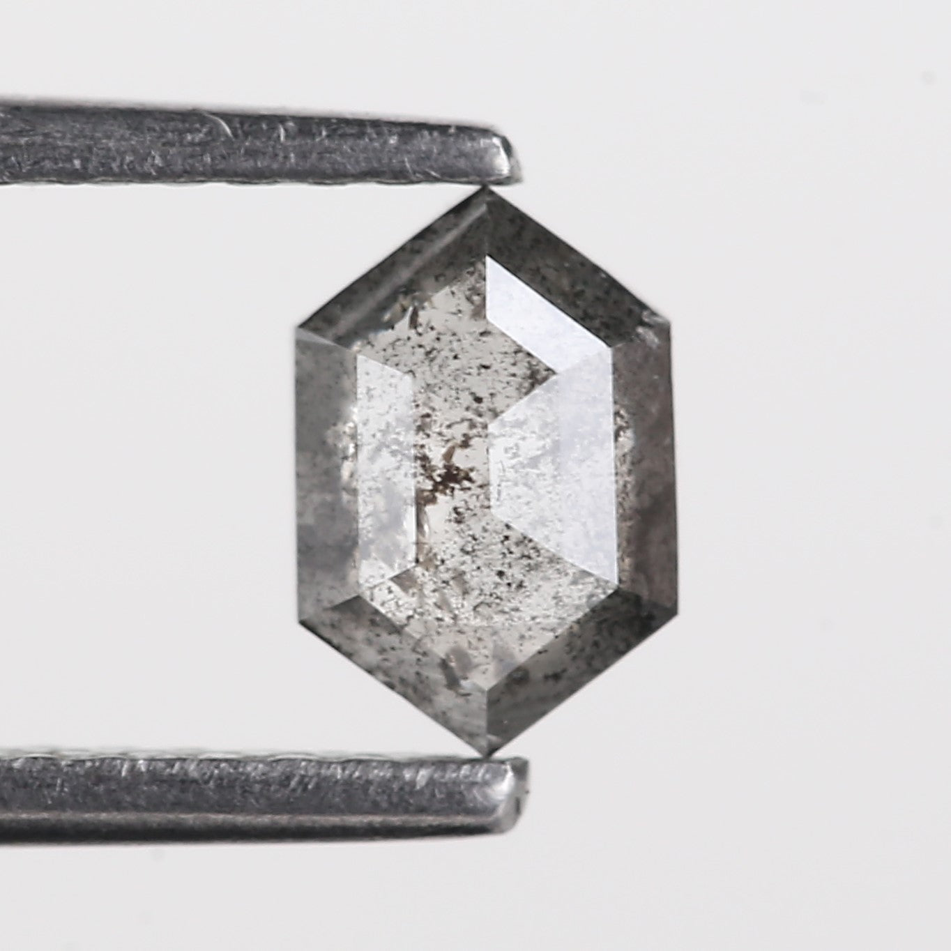 Hexagonal crystal with rough edges on a light gray background
