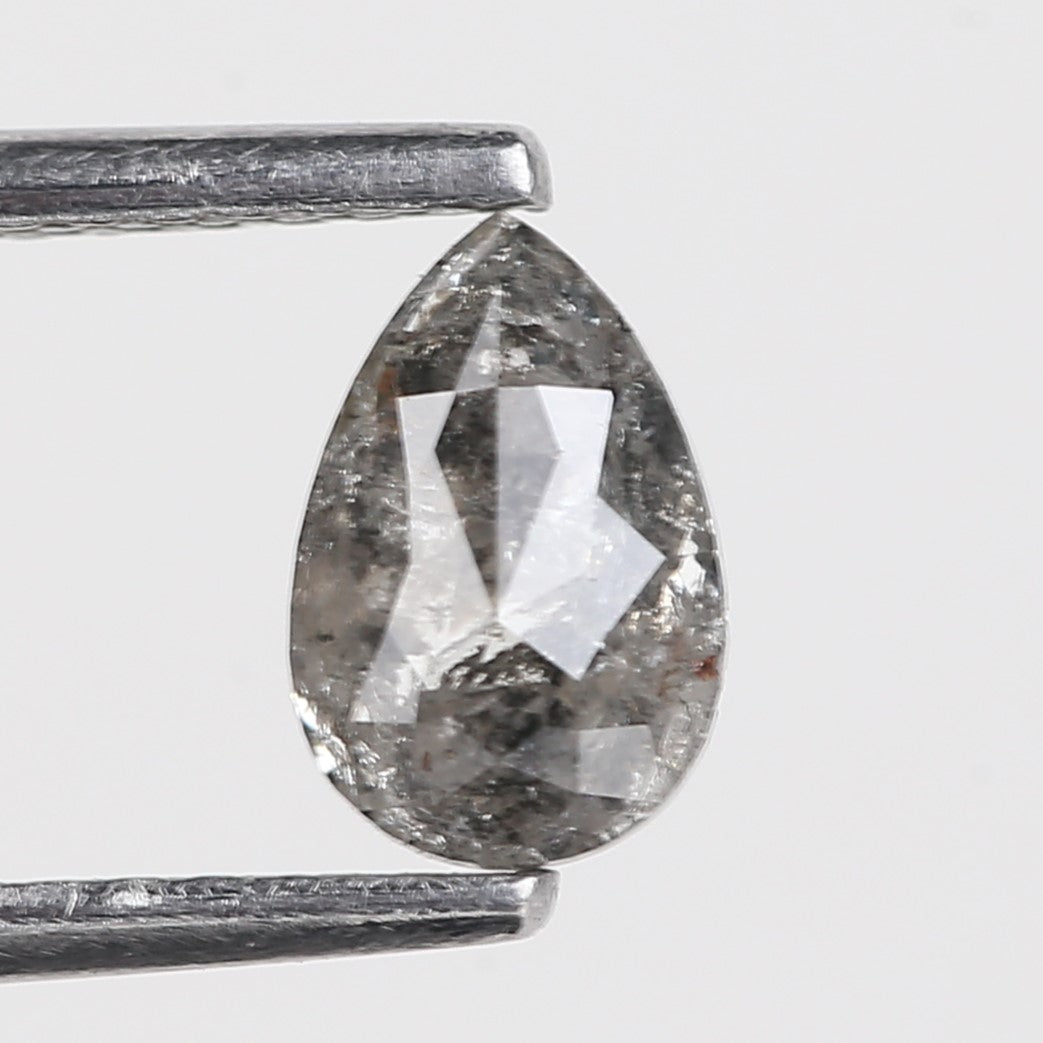 Teardrop-shaped diamond with a silver prong setting on a light gray background