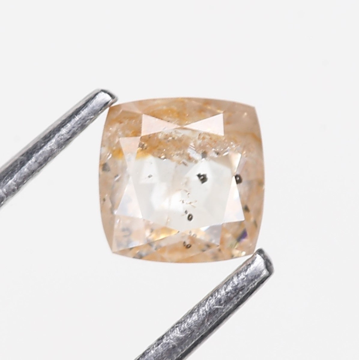 Square-cut diamond with a metal gage on a white background