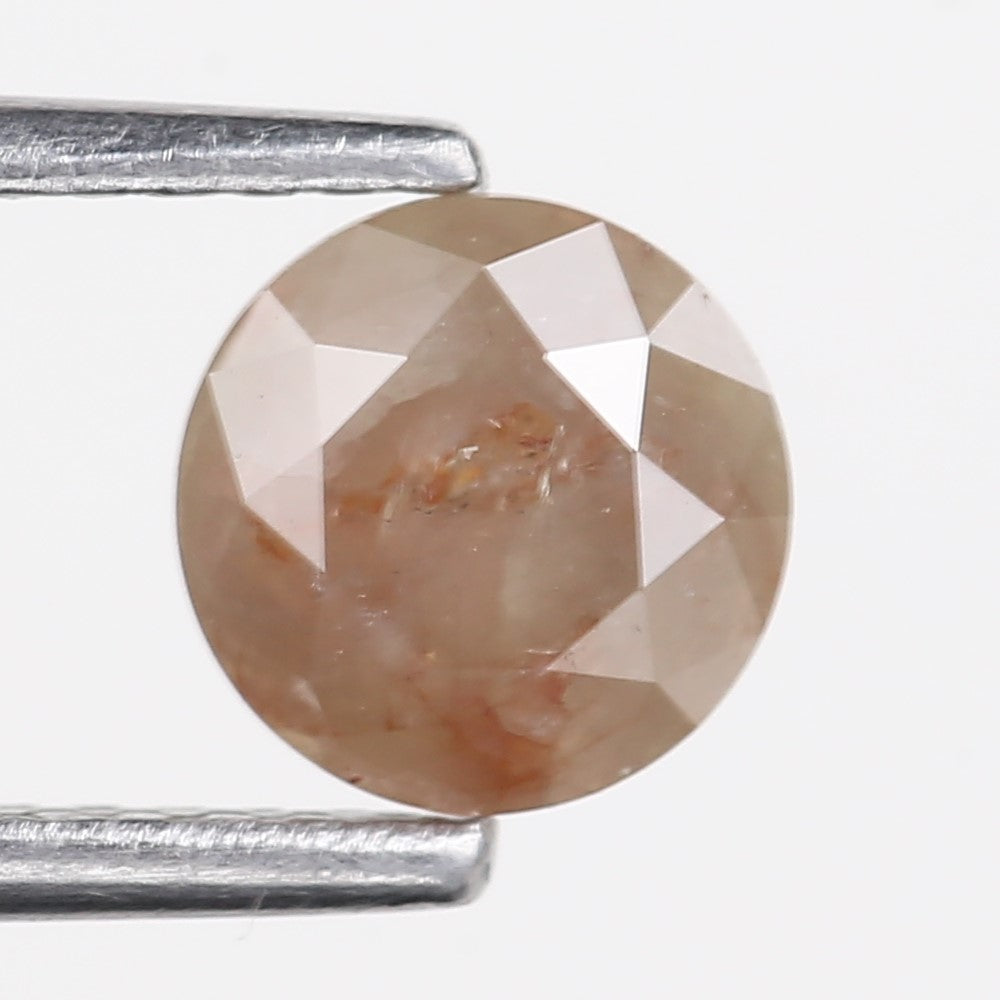 Brown gemstone held between two metal prongs on a white background