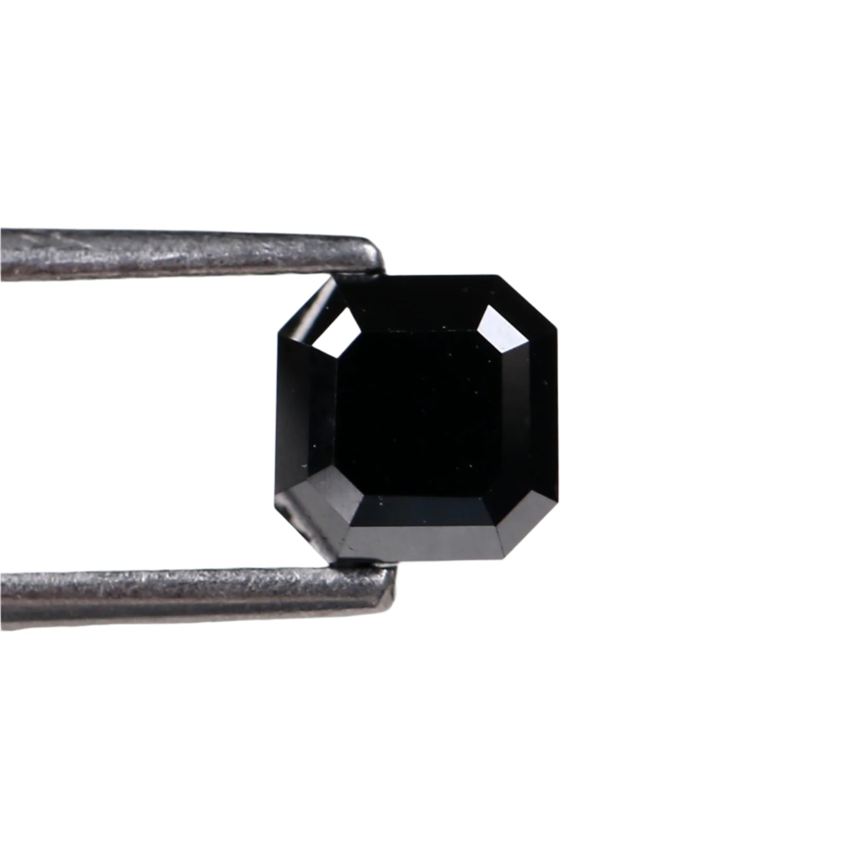 Black diamond held by tweezers on a white background