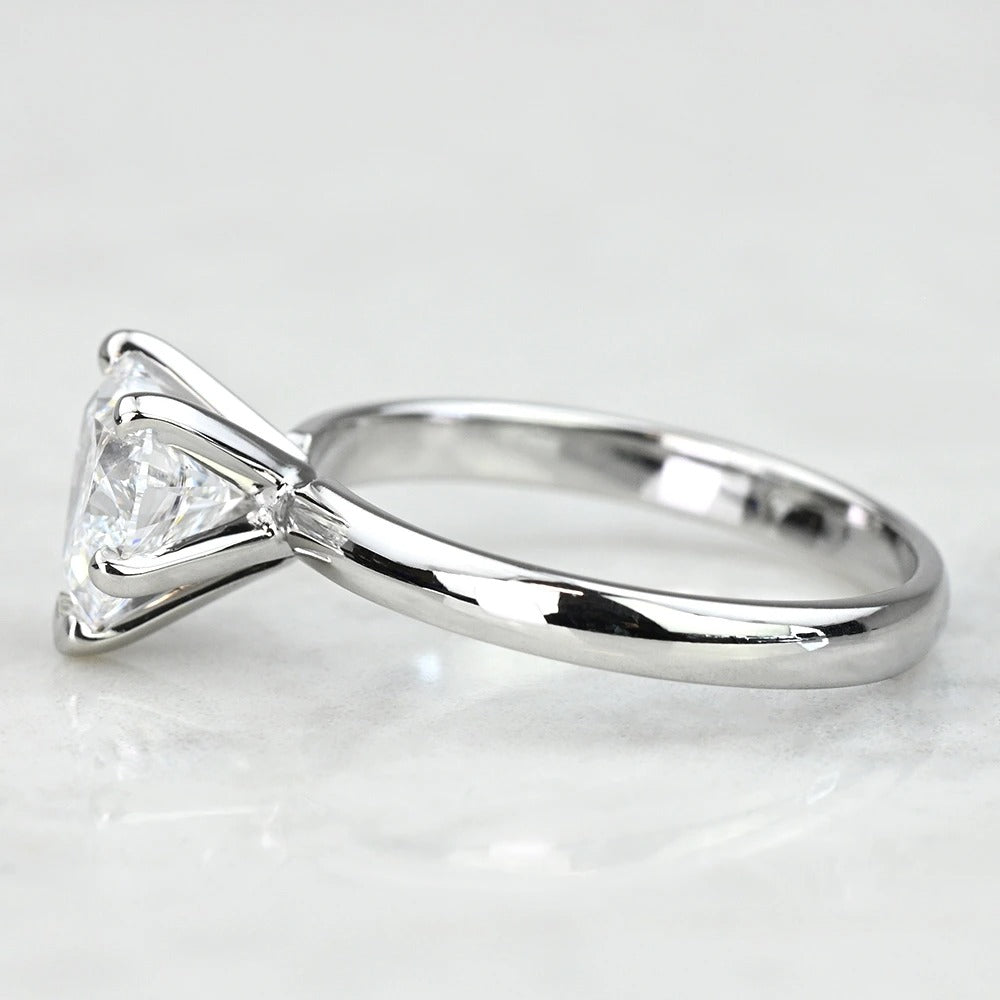 white gold ring with a triangle-cut diamond on a light gray background