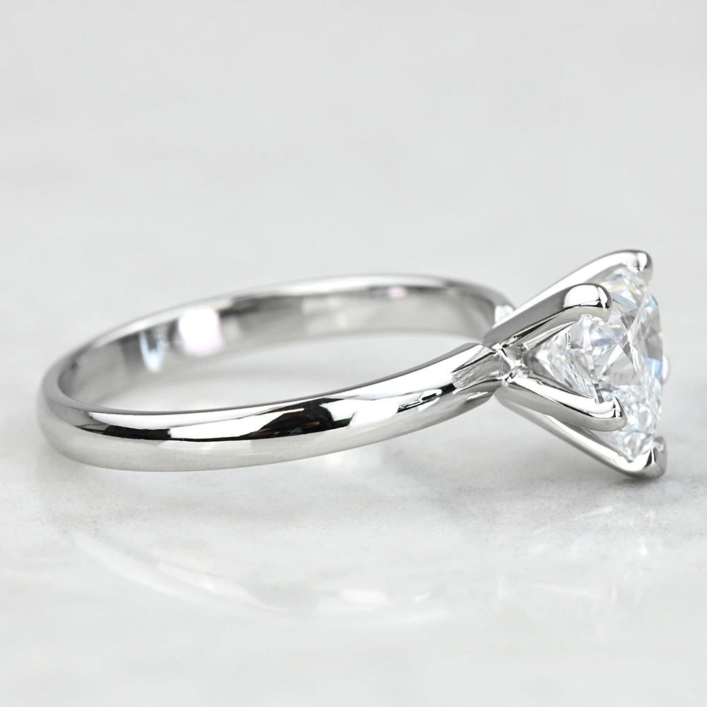 white gold ring with a triangular diamond on a light gray background