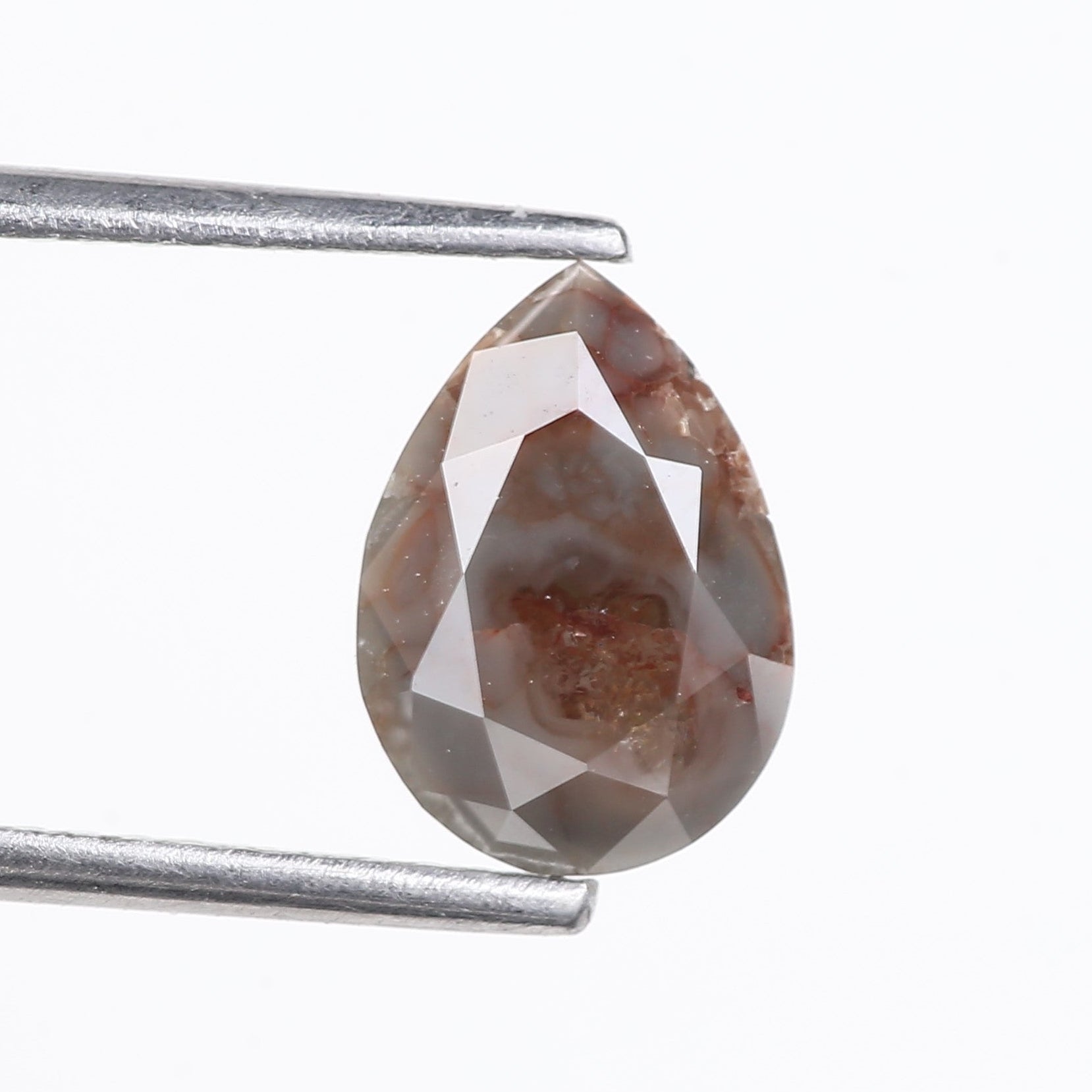 Teardrop-shaped brown gemstone held by tweezers on a white background