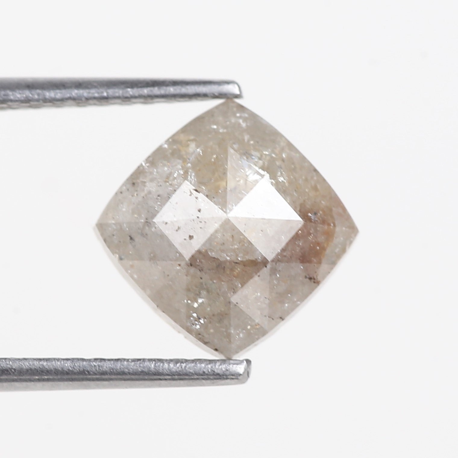 Faceted diamond held by tweezers on a white background