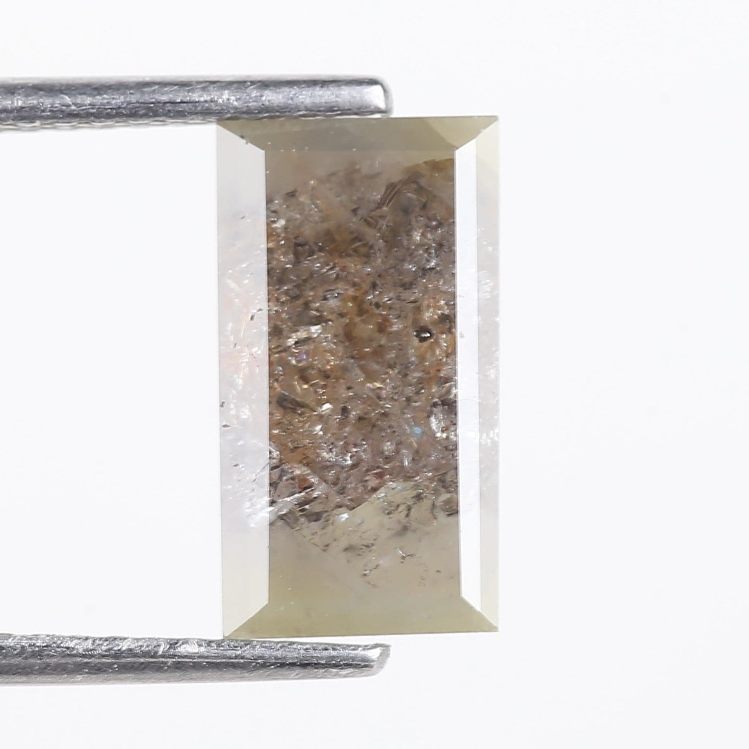 Rectangular cut gemstone with visible inclusions on a white background