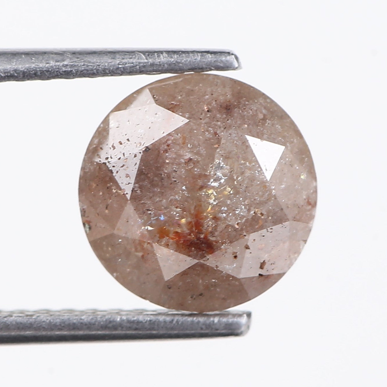 PEACH diamond held between tweezers on a white background