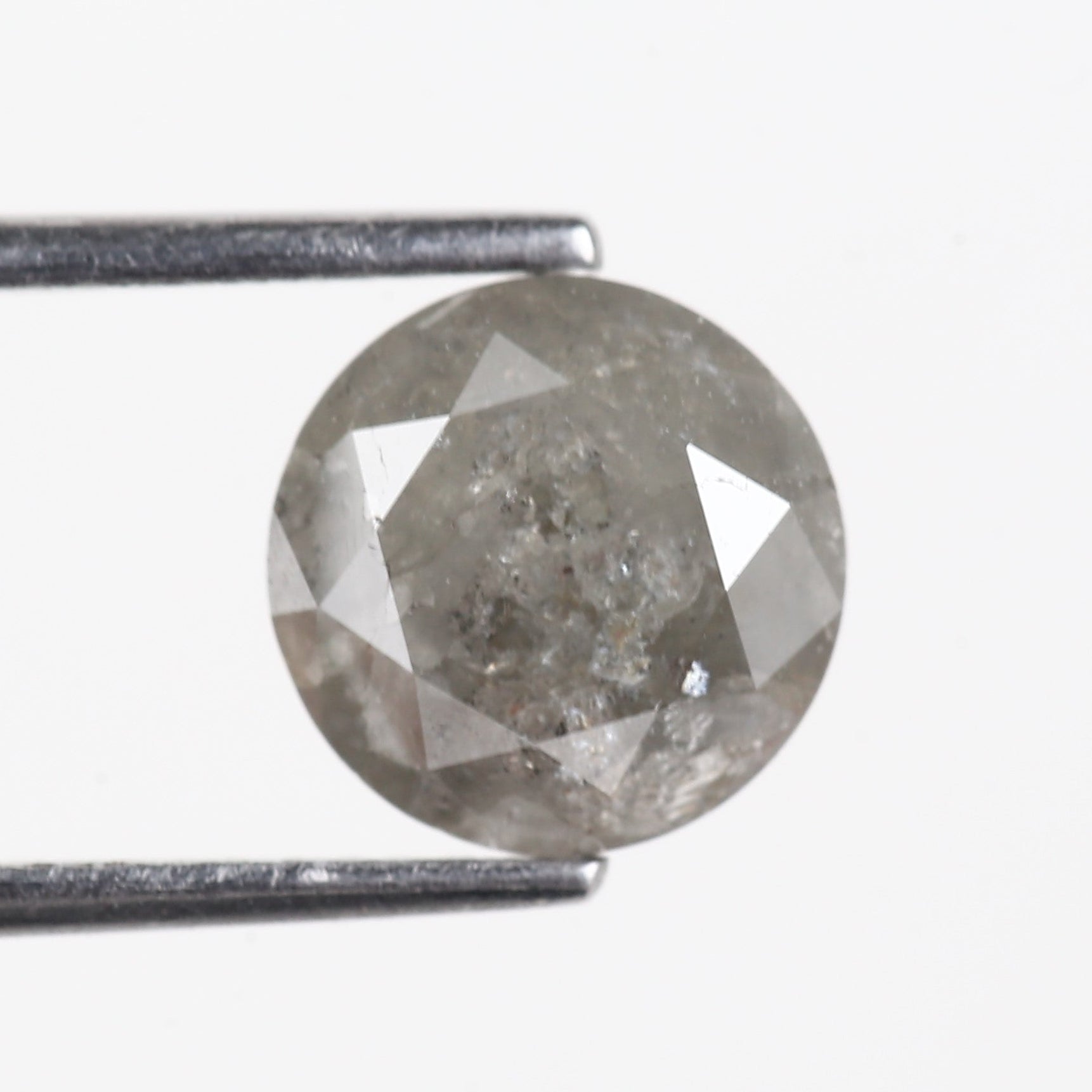 Round diamond held by tweezers on a white background