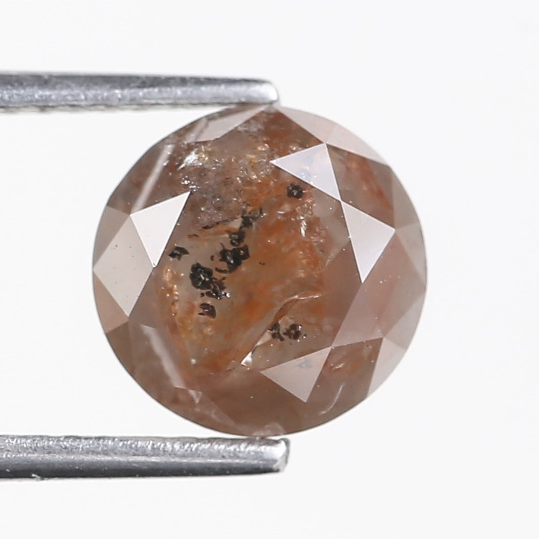 Fancy Orange Brown diamond with visible inclusions on a white background
