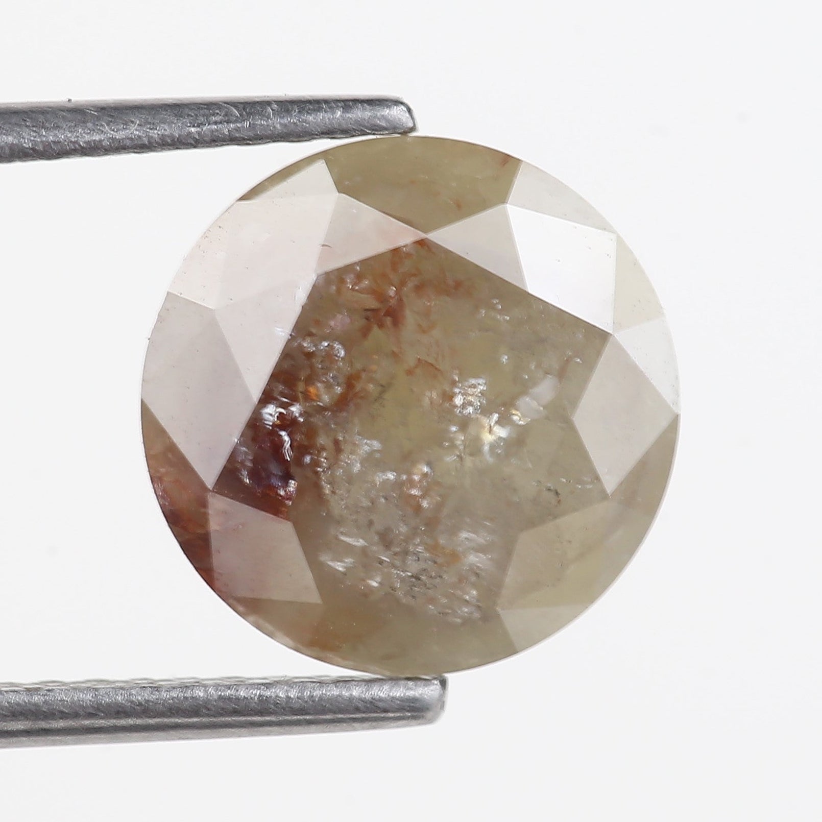 Faceted DIAMOND held between tweezers on a white background