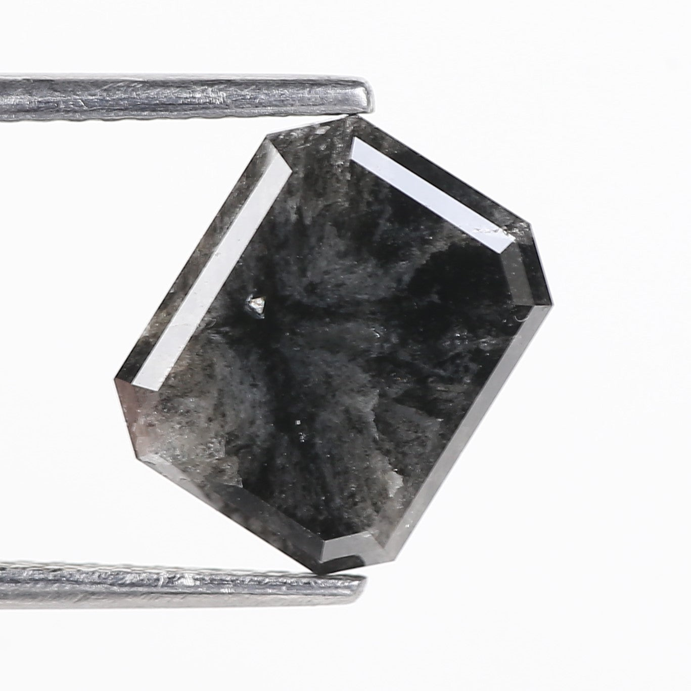 Hexagonal black stone with a metallic rod on a white background