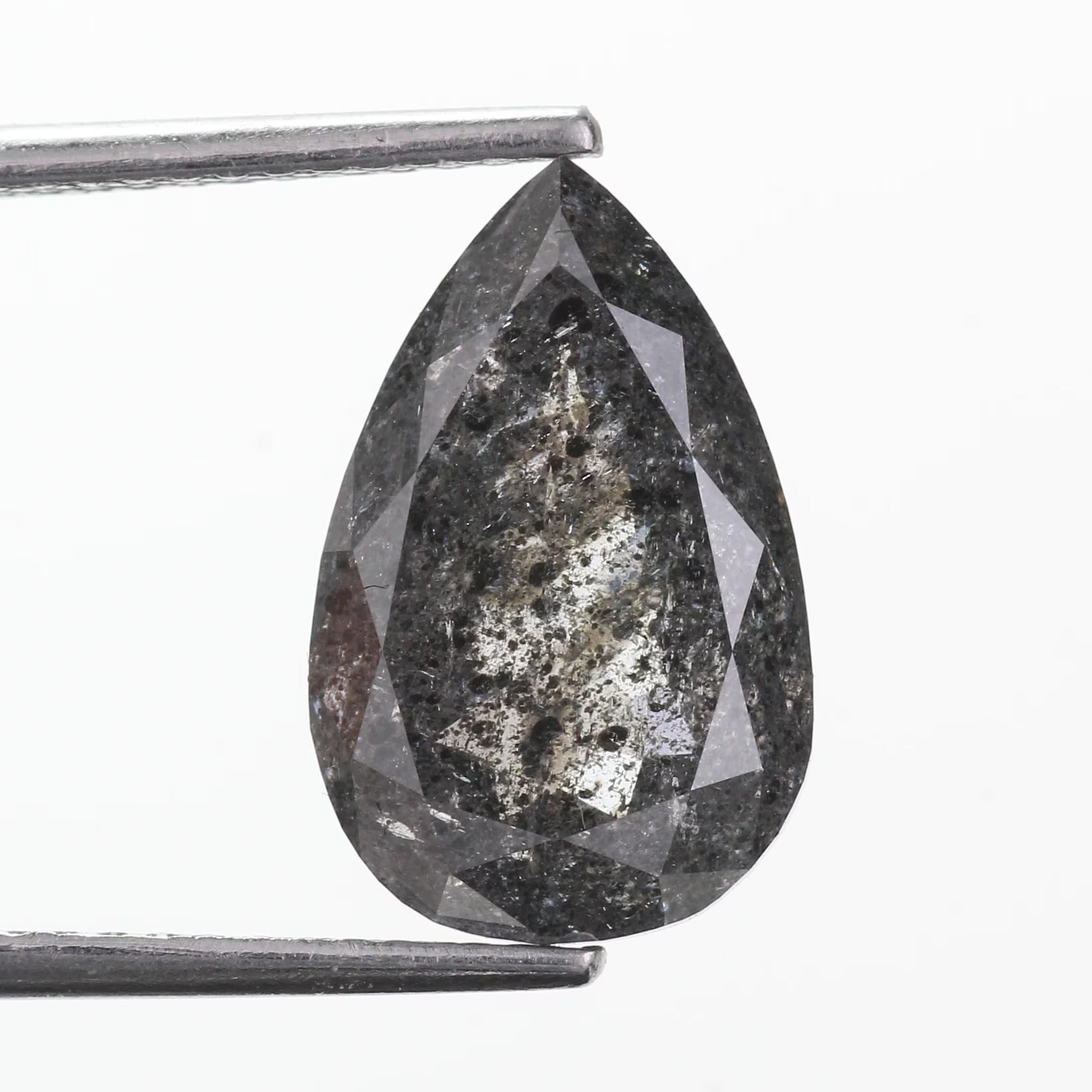 A faceted pear-shaped dark gray diamond held between metal tweezers against a plain white background.