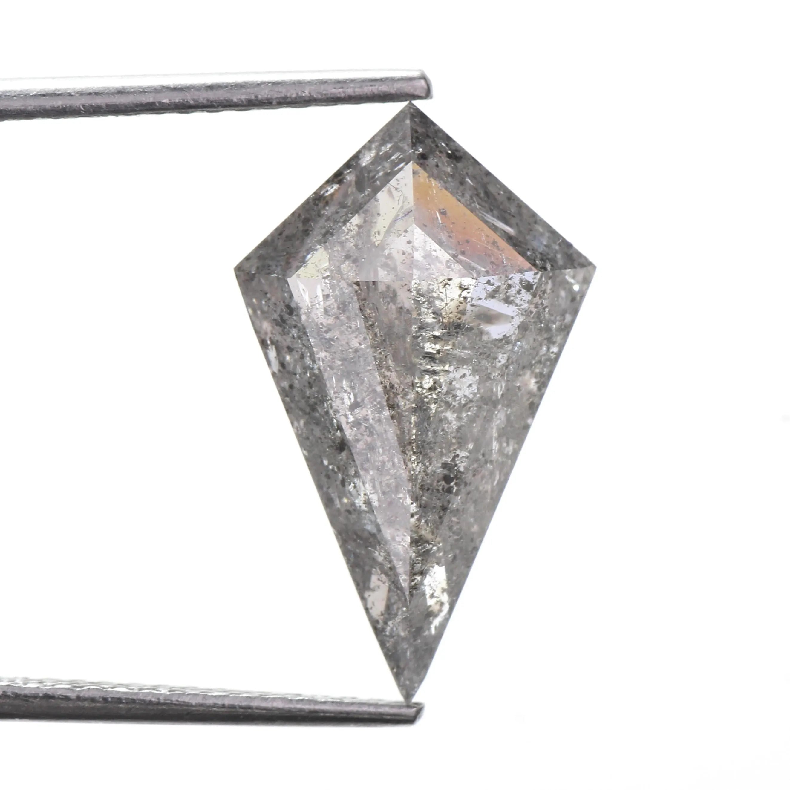 A loose, natural pointed kitee cut clear diamond held between metal tweezers against a plain white background.